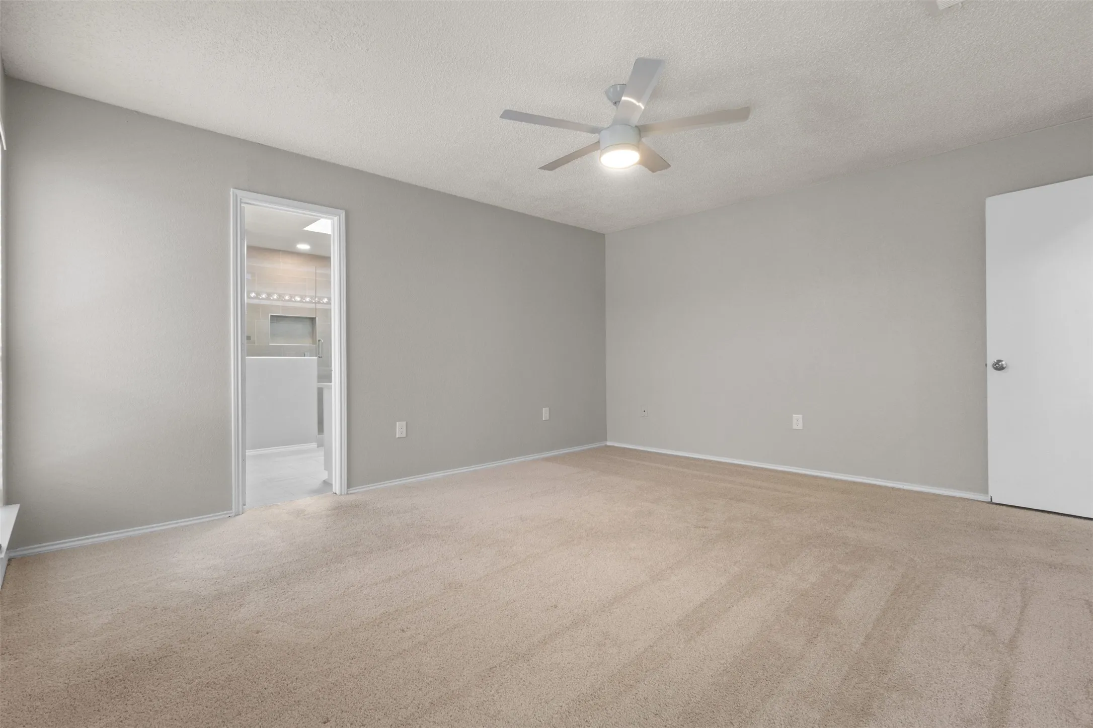 Neutral wall tones, carpet flooring, ceiling fan with integrated lighting, and white trim throughout