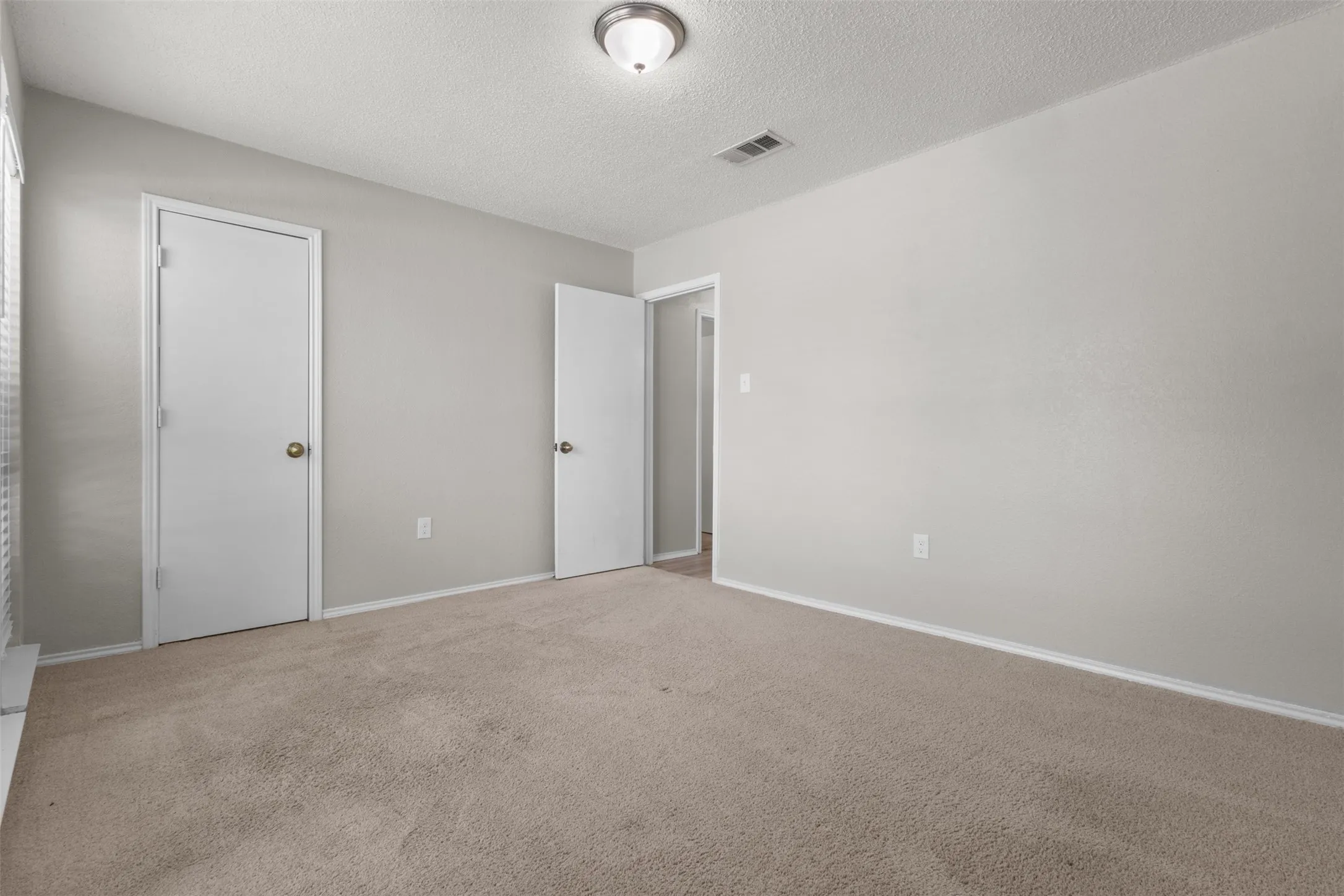 Light-colored carpeting with matching wall tones and white trim