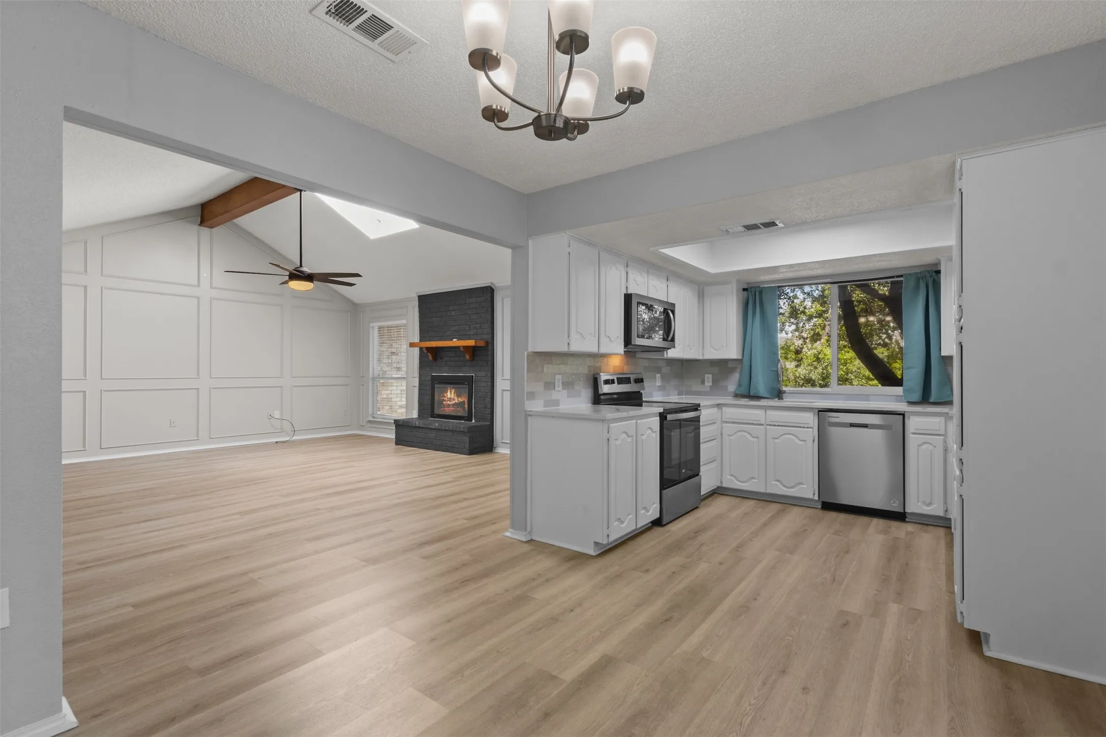 Wood-finish flooring throughout, with a vaulted ceiling and exposed beam
