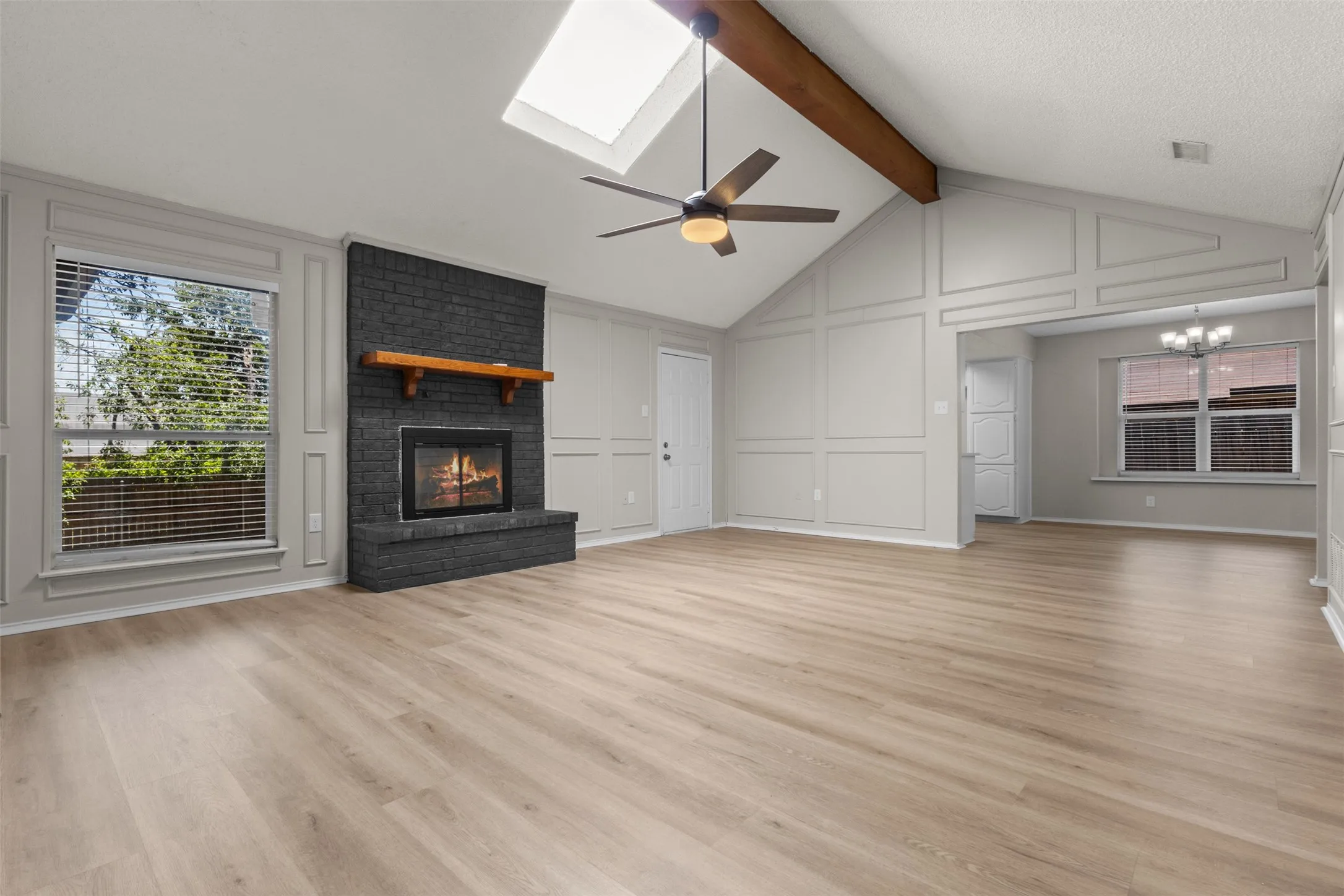 Vaulted ceilings with exposed beam, skylight, and a ceiling fan