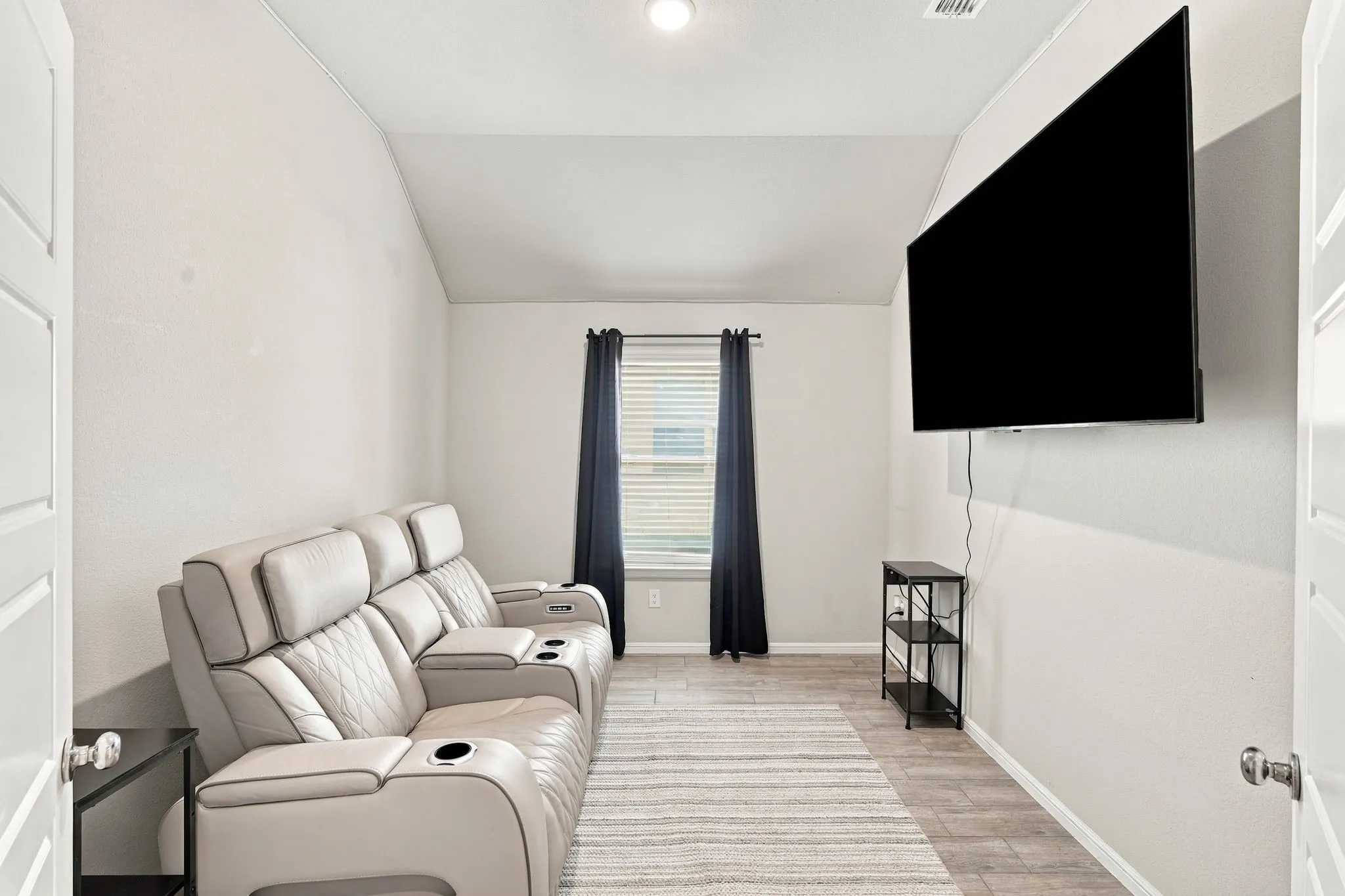 Room featuring a vaulted ceiling and tile flooring