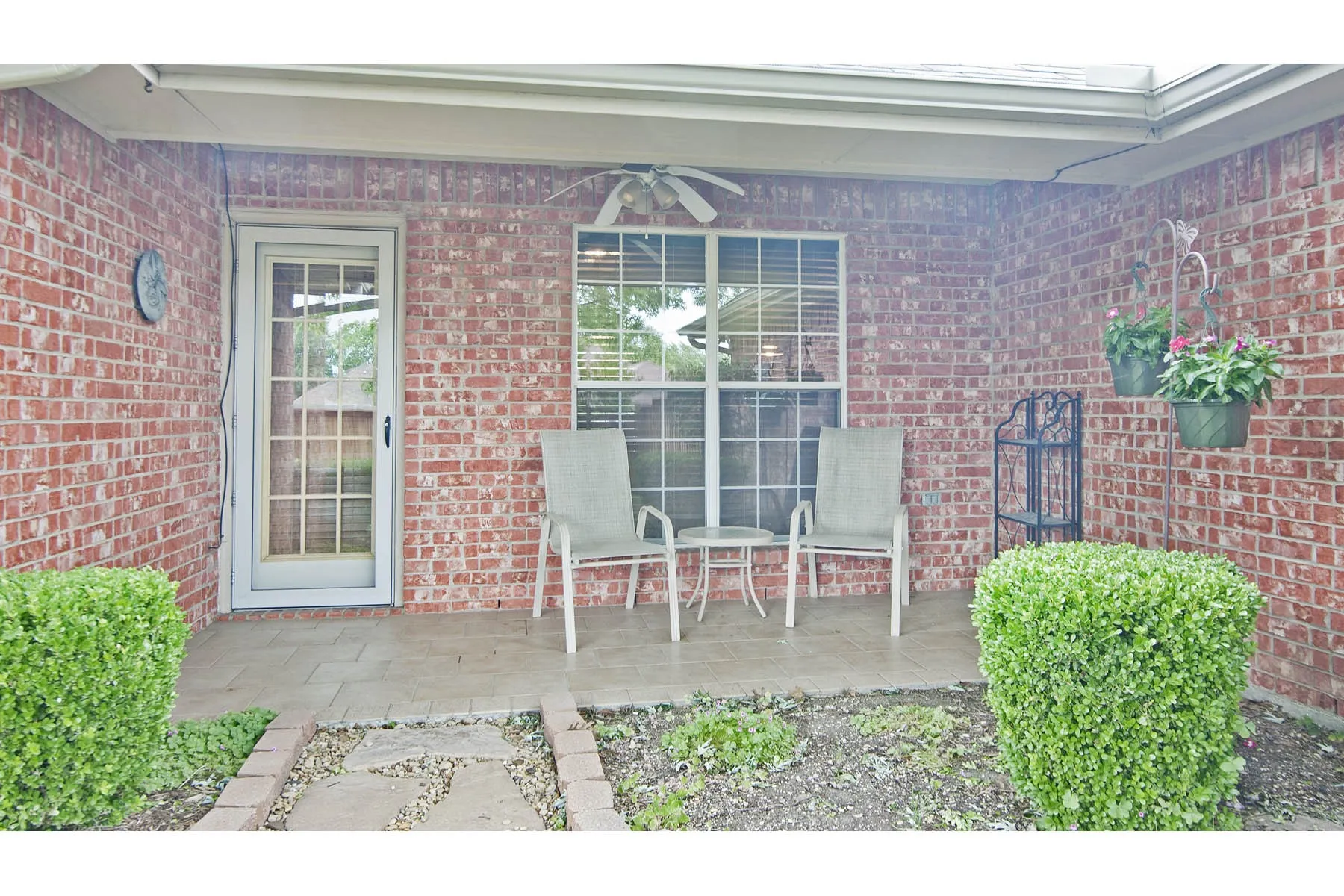 Doorway to property featuring brick siding and ceiling fan