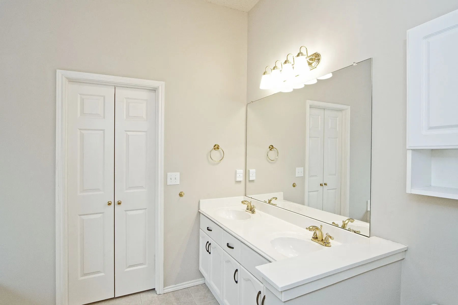 Bathroom with double vanity, baseboards, and a sink