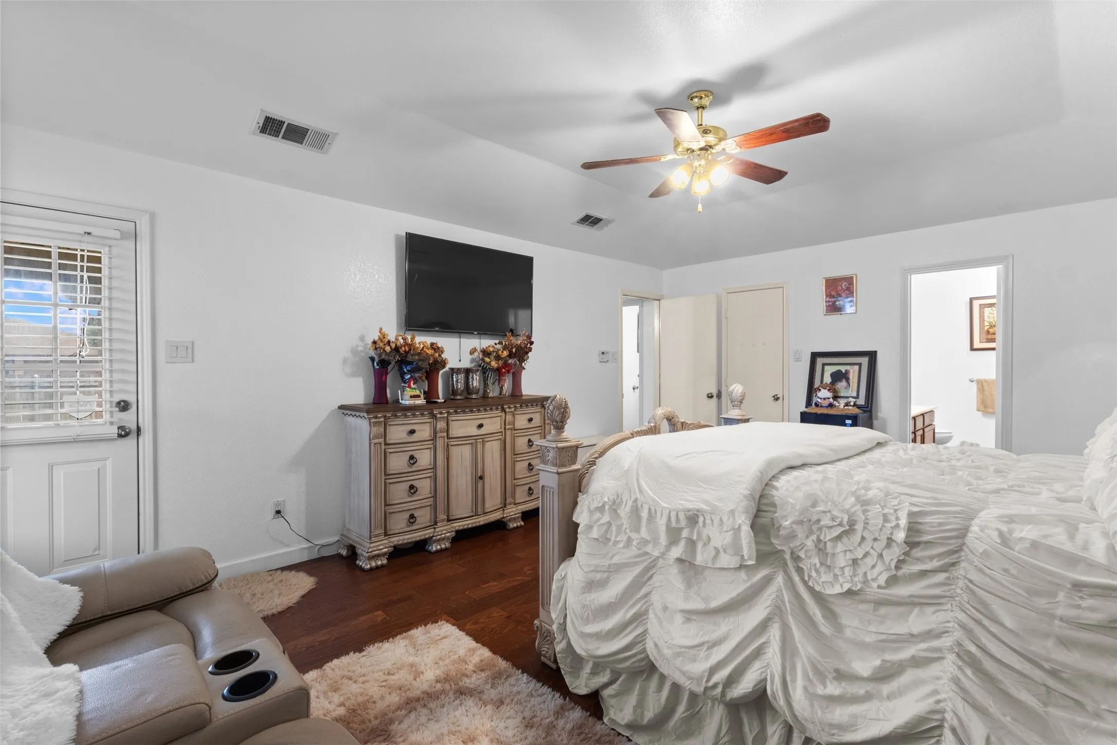 Wood-finish flooring, ceiling fan with integrated lighting, and multiple paneled doors