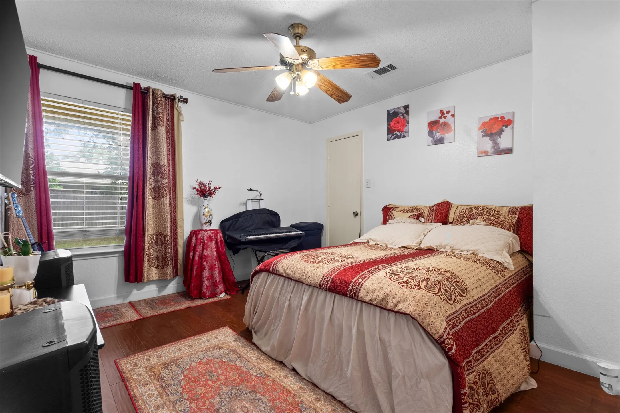 Wood-finish flooring, ceiling fan with light fixture, window with blinds, and white interior door