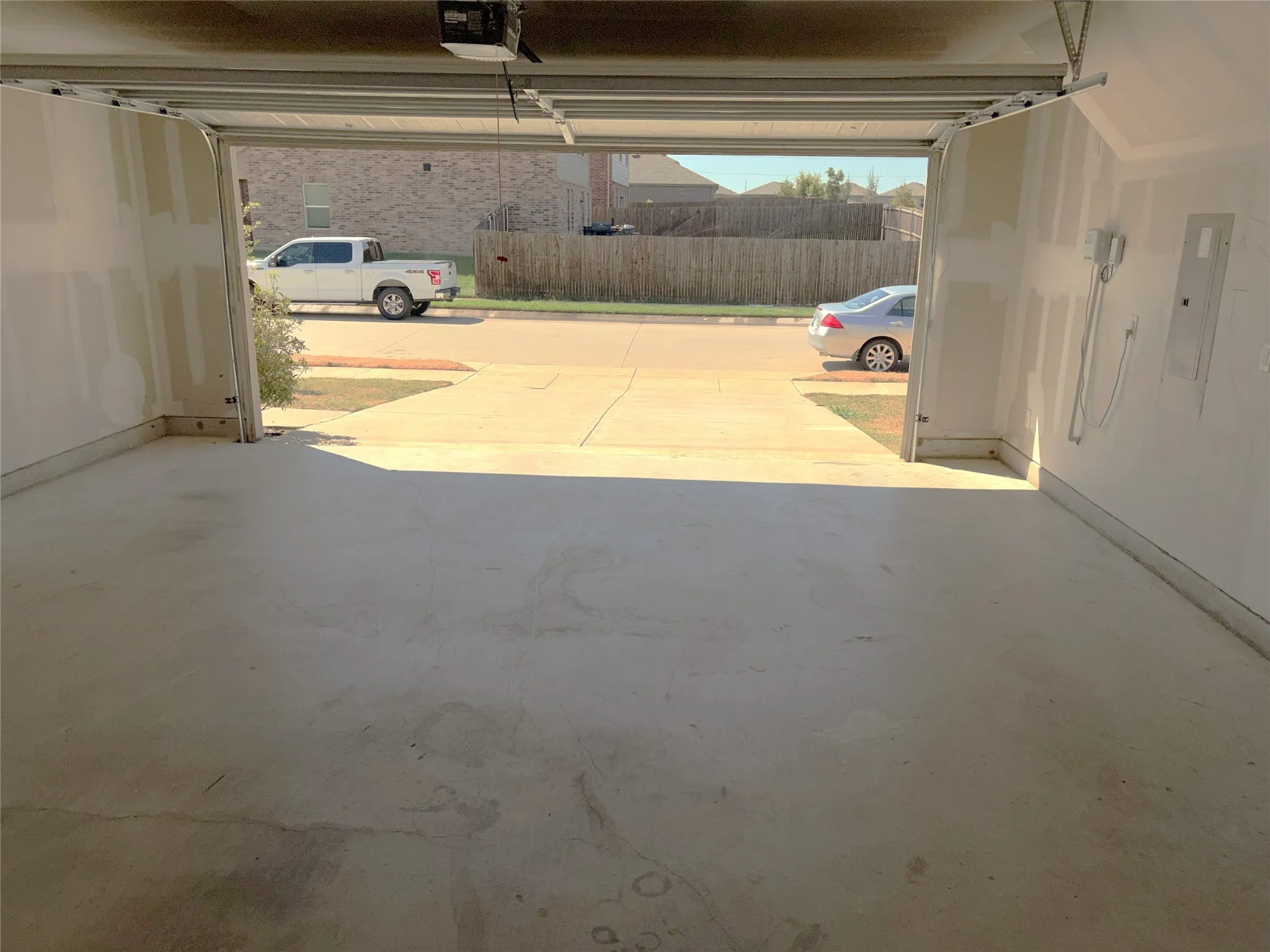 Attached garage with concrete flooring and drywall ready walls