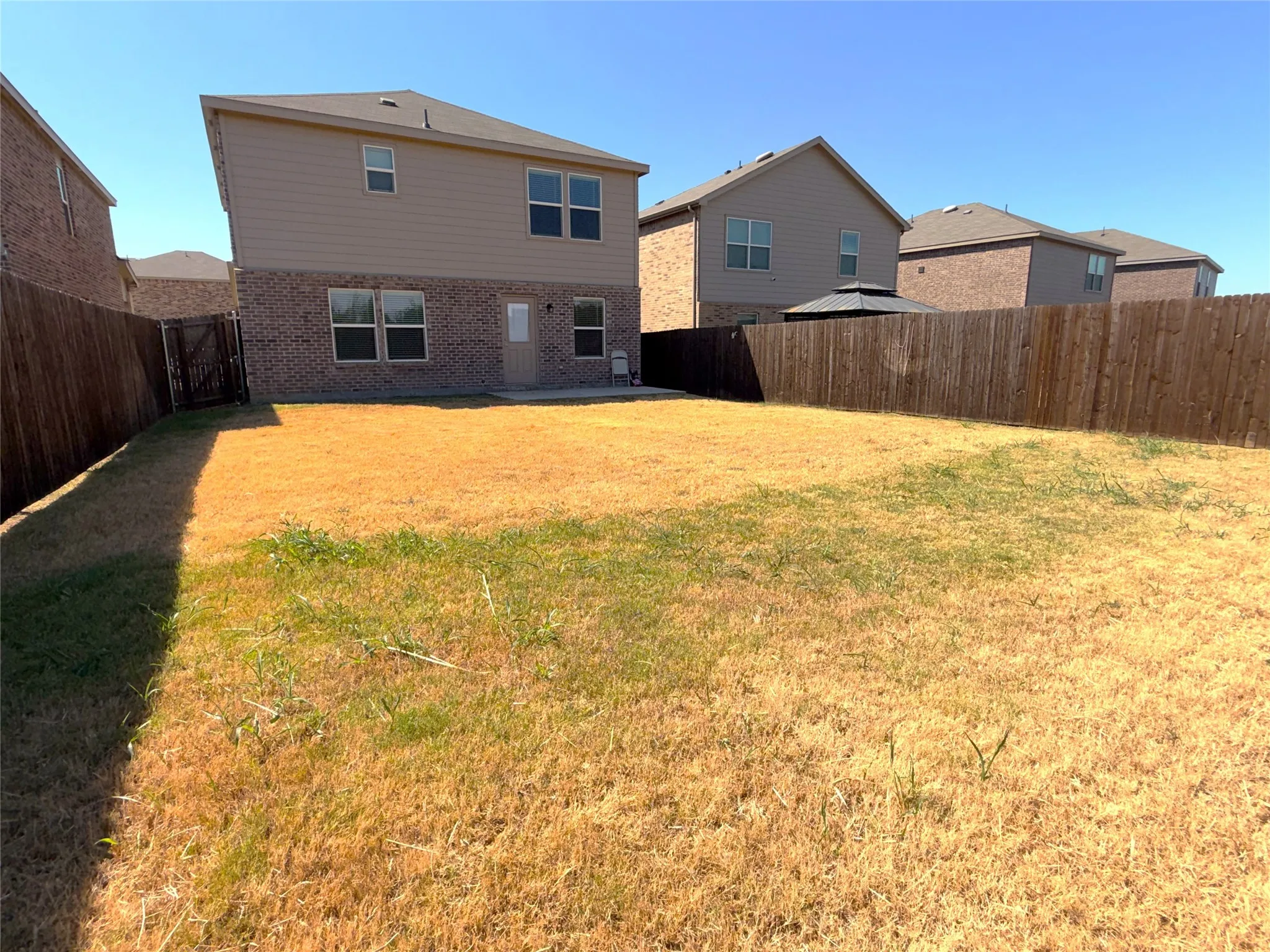 Back yard with wooden privacy fence and irrigation system.