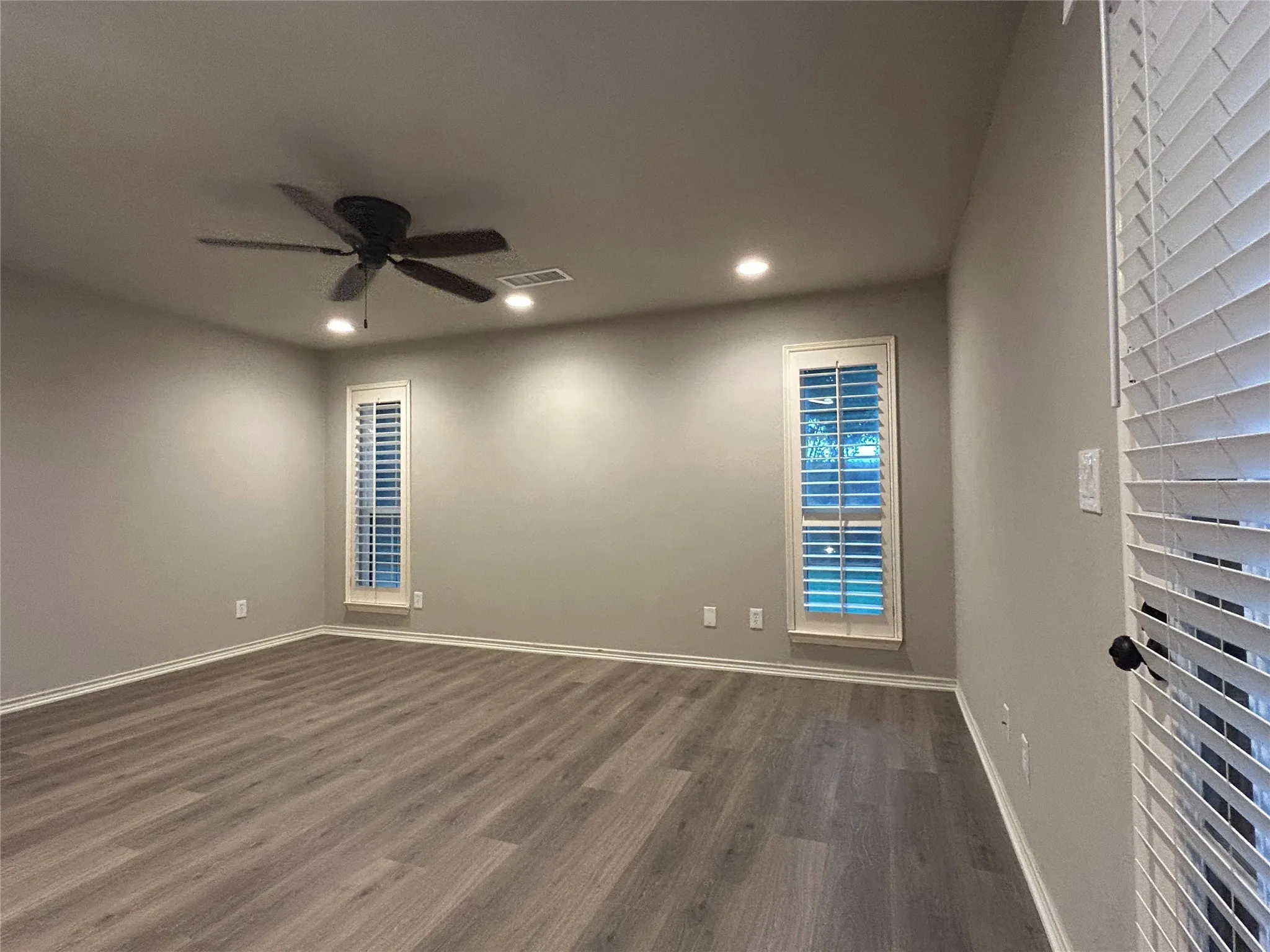 The primary bedroom has a door to the covered patio, plantation shutters, and an ensuite bathroom.
