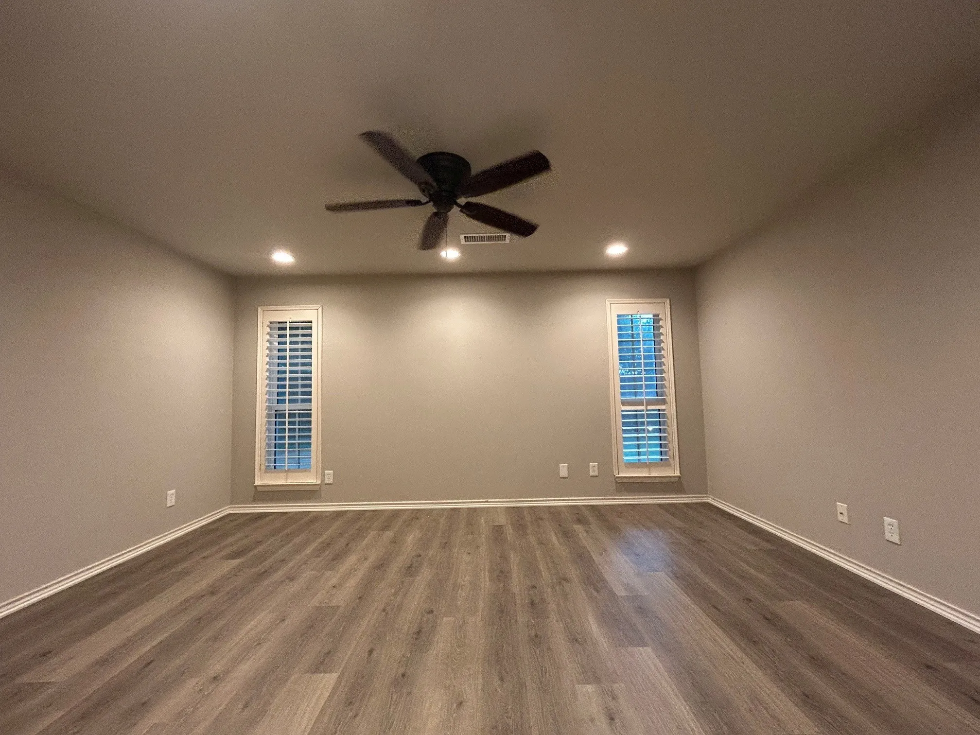 The primary bedroom has been freshly painted with new flooring.  It has recessed lighting, a ceiling fan, and recessed lighting.