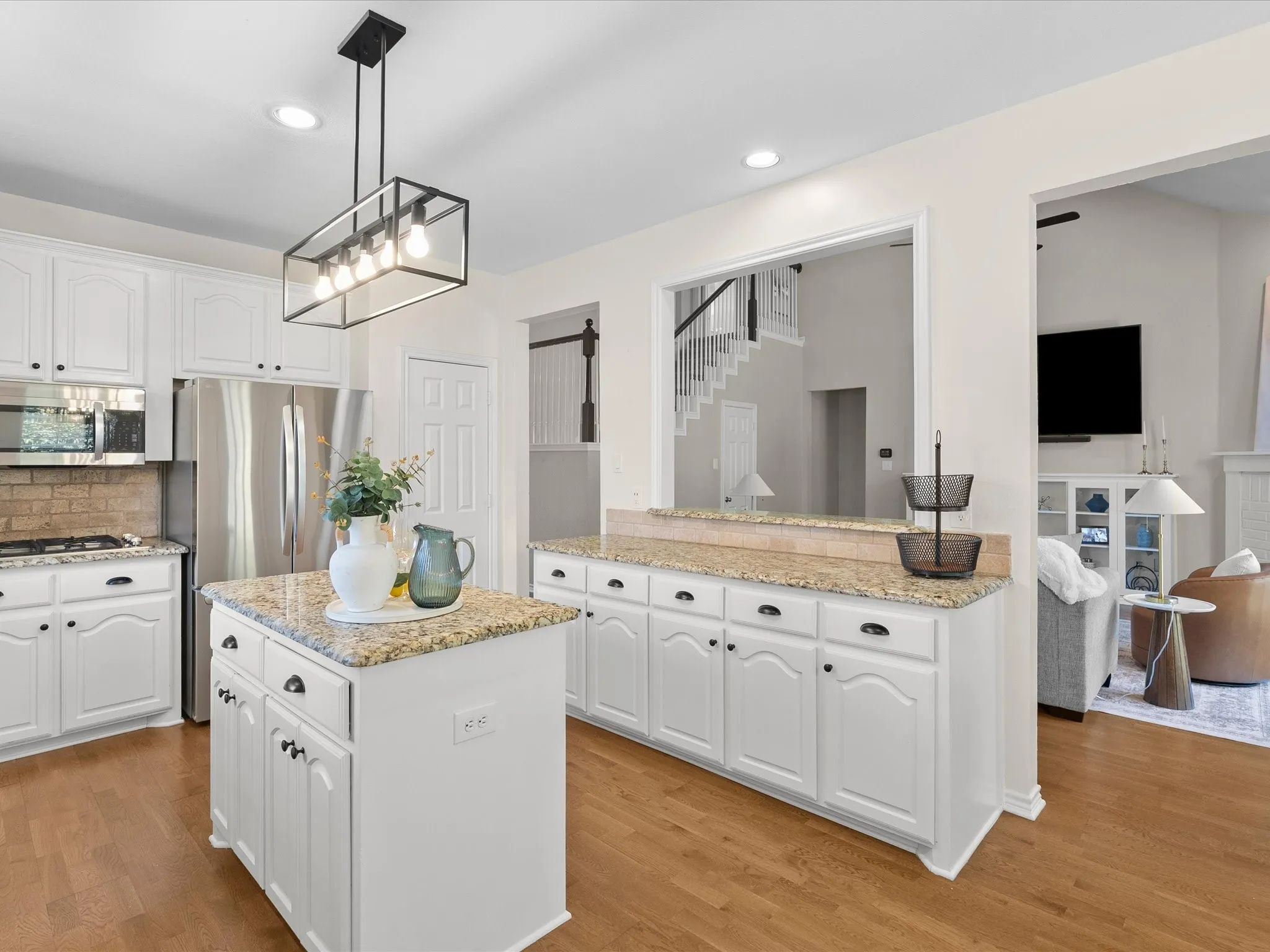 Kitchen featuring white cabinetry, a freestanding kitchen island with a granite countertop, and stainless steel appliances