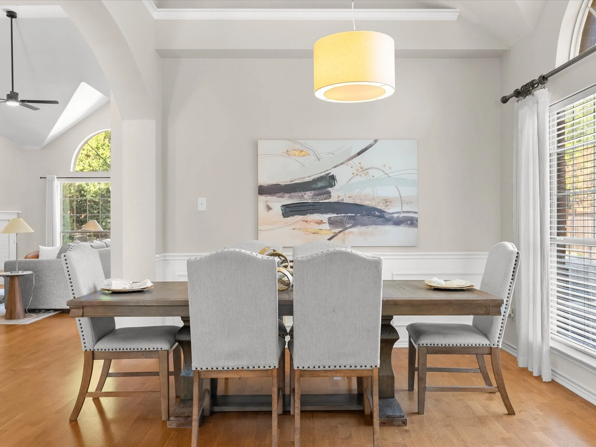 Hardwood flooring extending into the living area, crown molding, and wainscoting details
