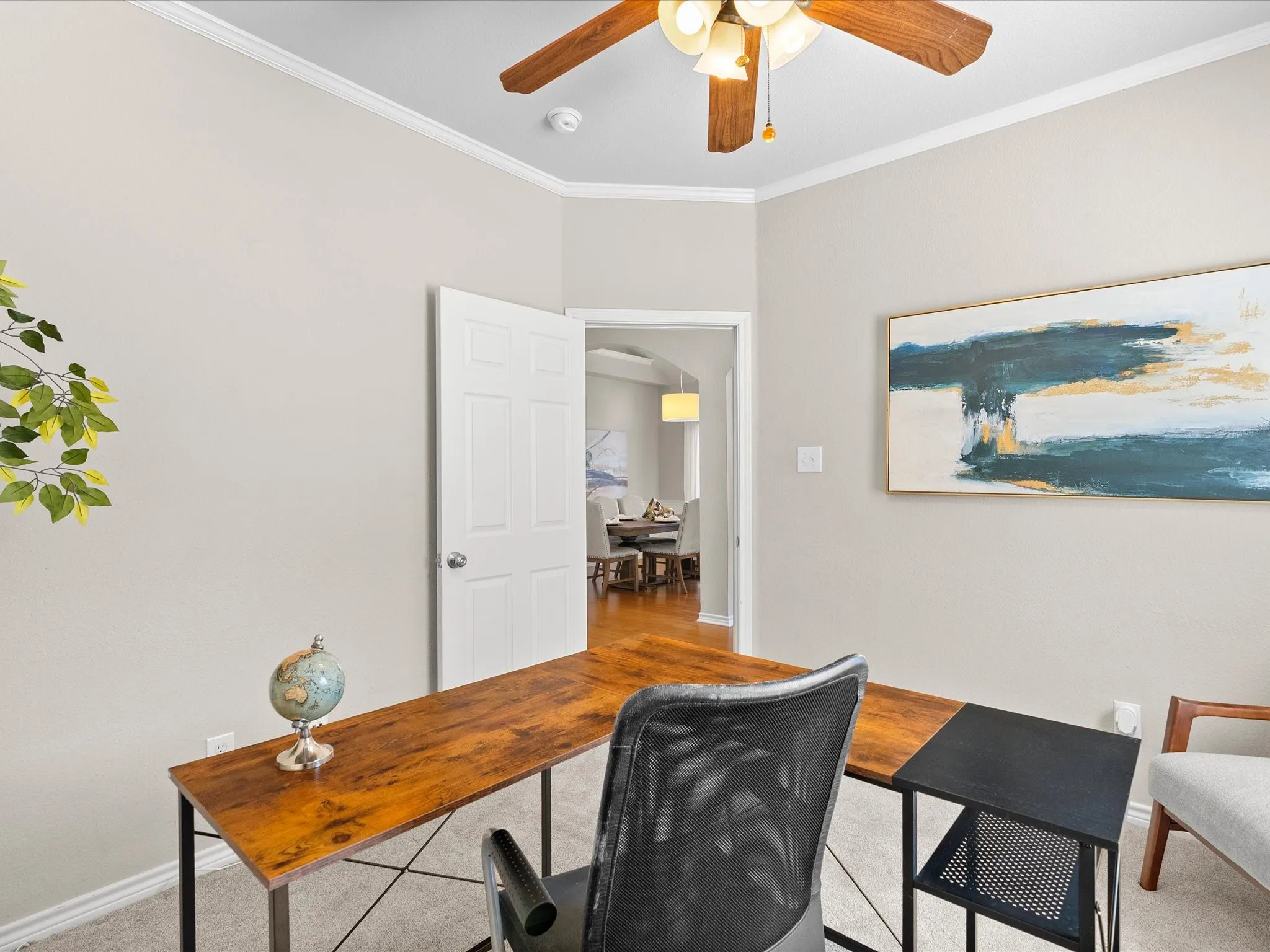 Crown molding, neutral wall color, ceiling fan with integrated lighting, paneled interior door, and carpet flooring