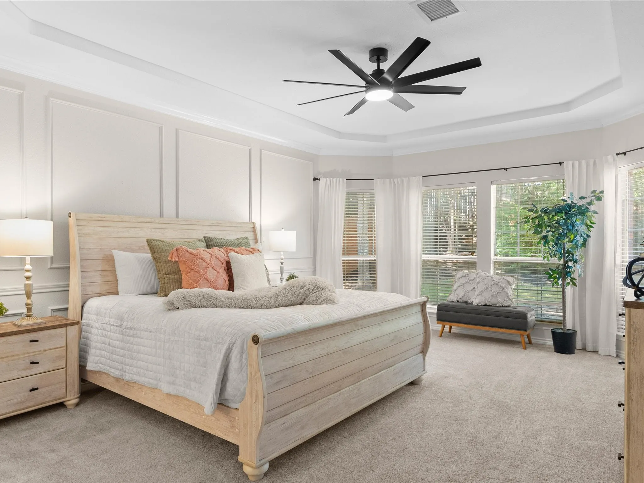 Tray ceiling, crown molding, wall paneling, large windows, ceiling fan