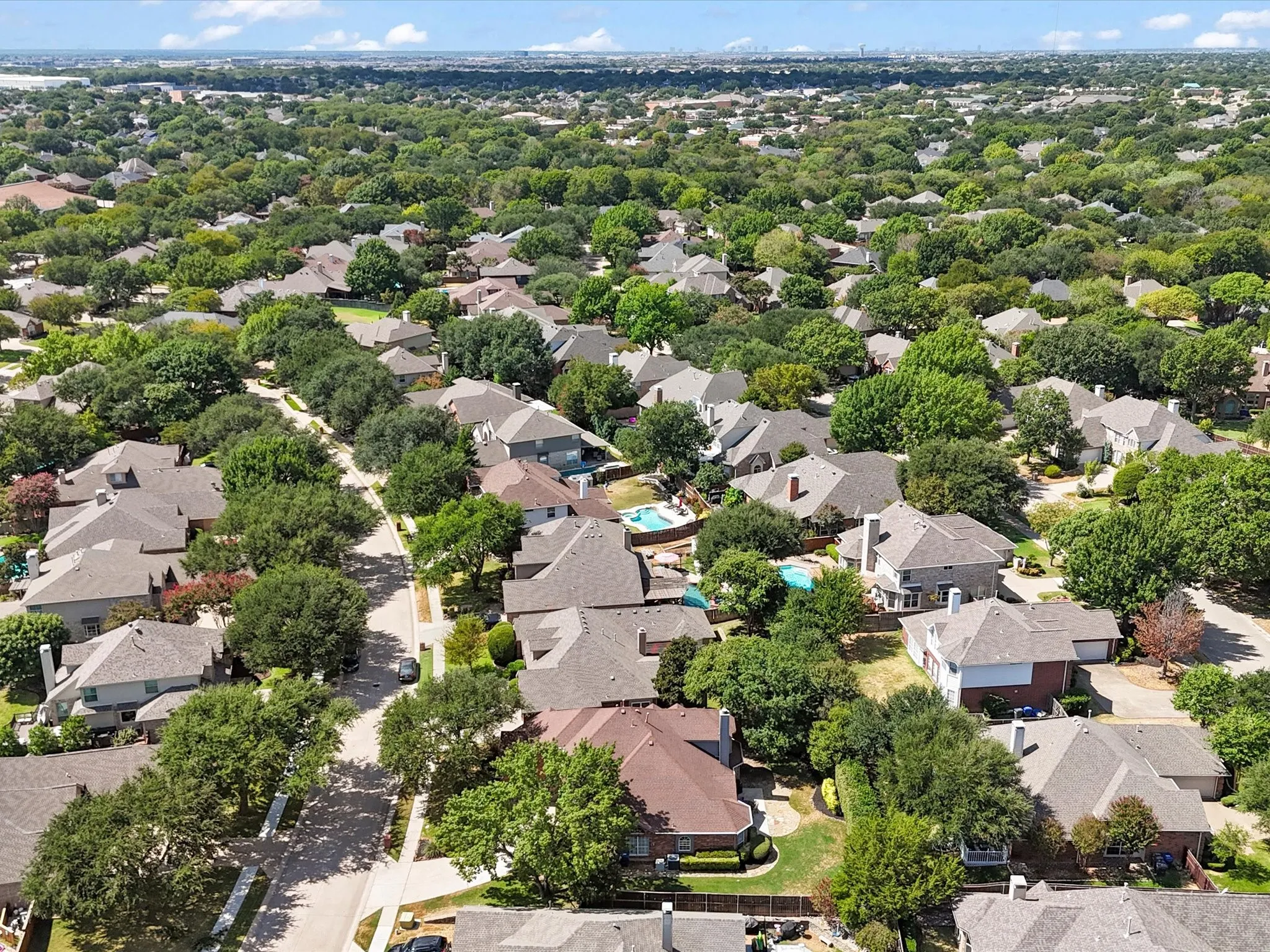 Aerial perspective showcasing a residential neighborhood with extensive mature tree canopy