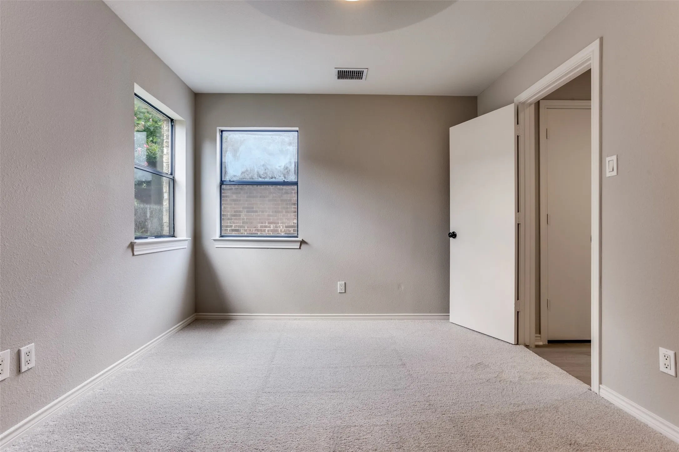 Neutral-toned walls complement plush carpeting