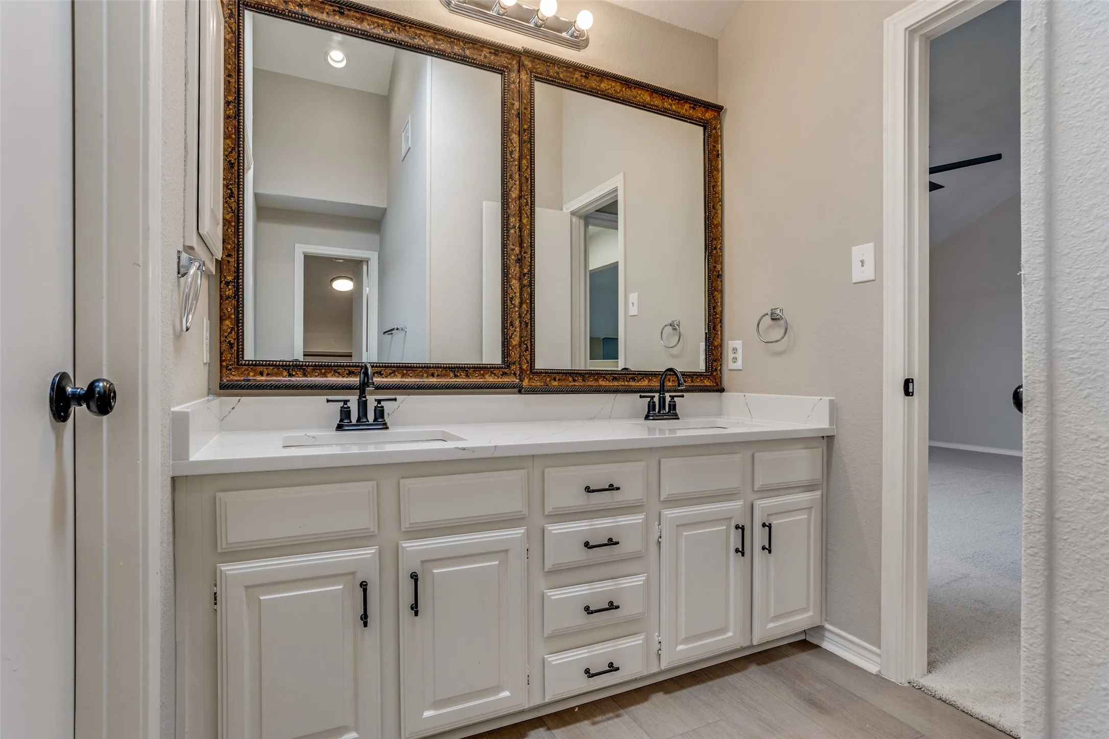 Dual vanity with white cabinetry and black hardware