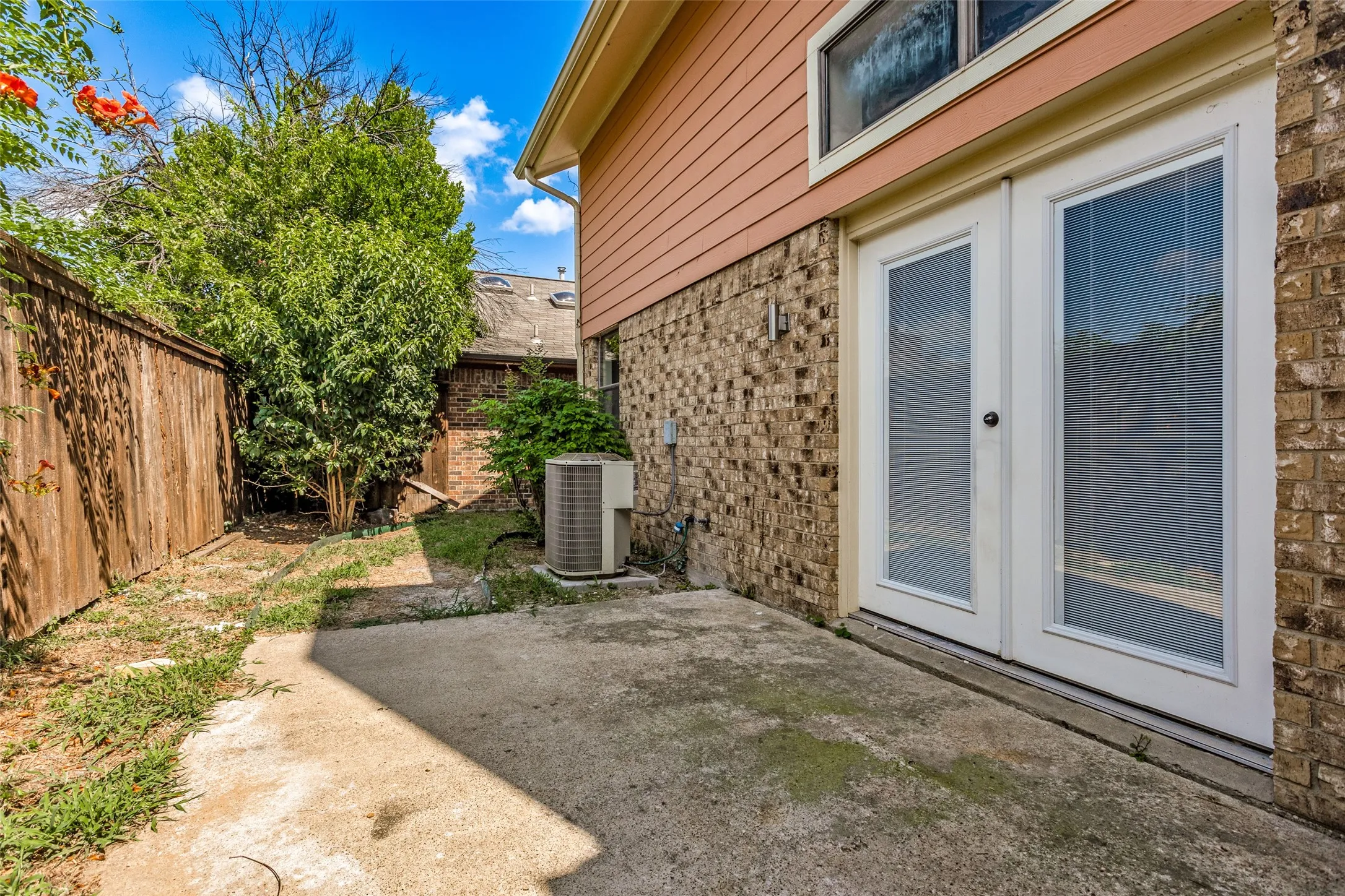 Private concrete patio with double-paned glass doors and a transom window