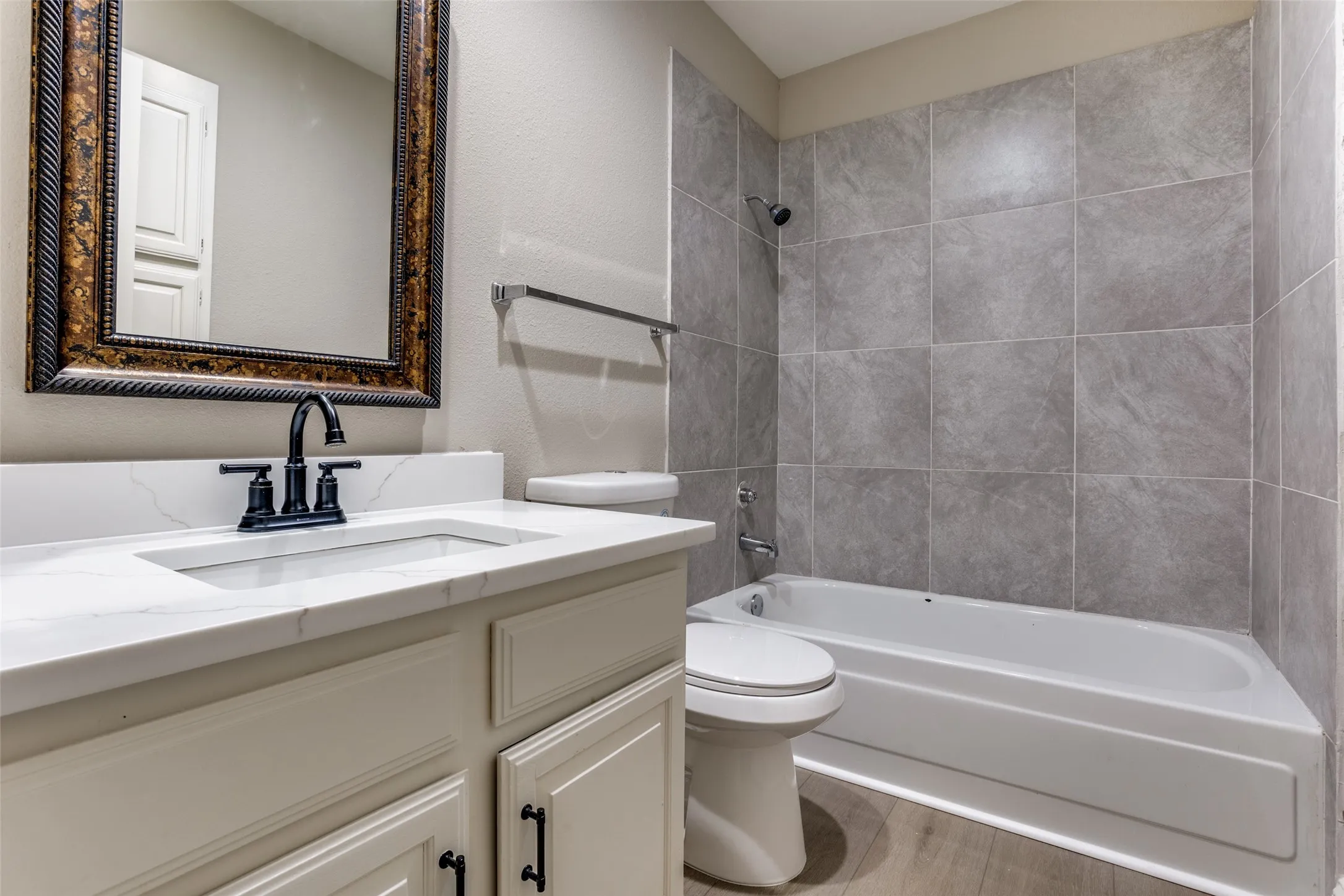 White vanity with matte black hardware and a white countertop, featuring an undermount sink with a matte black faucet