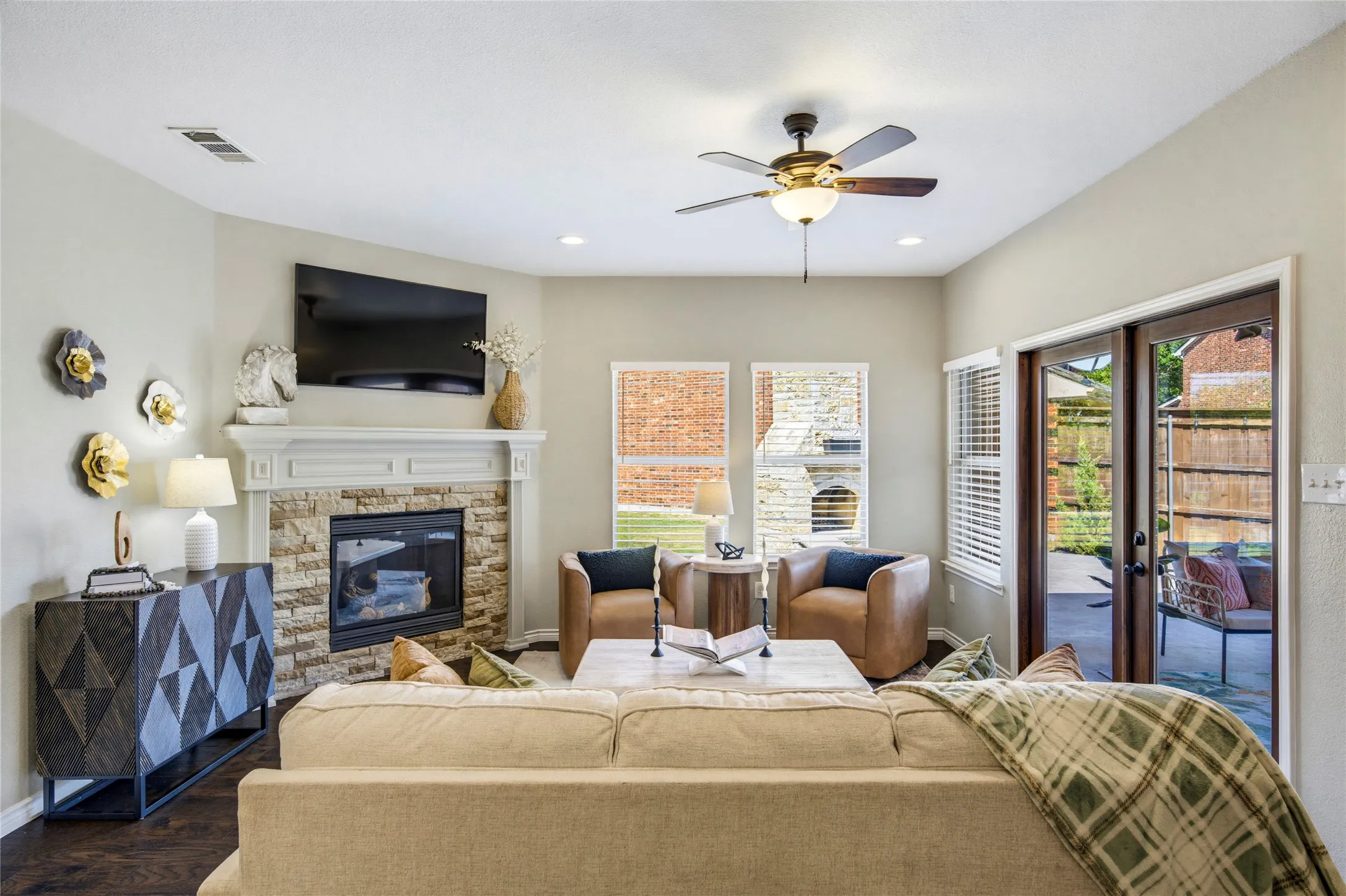 Large windows overlook the backyard, connecting the living room to the outdoor living spaces just beyond.