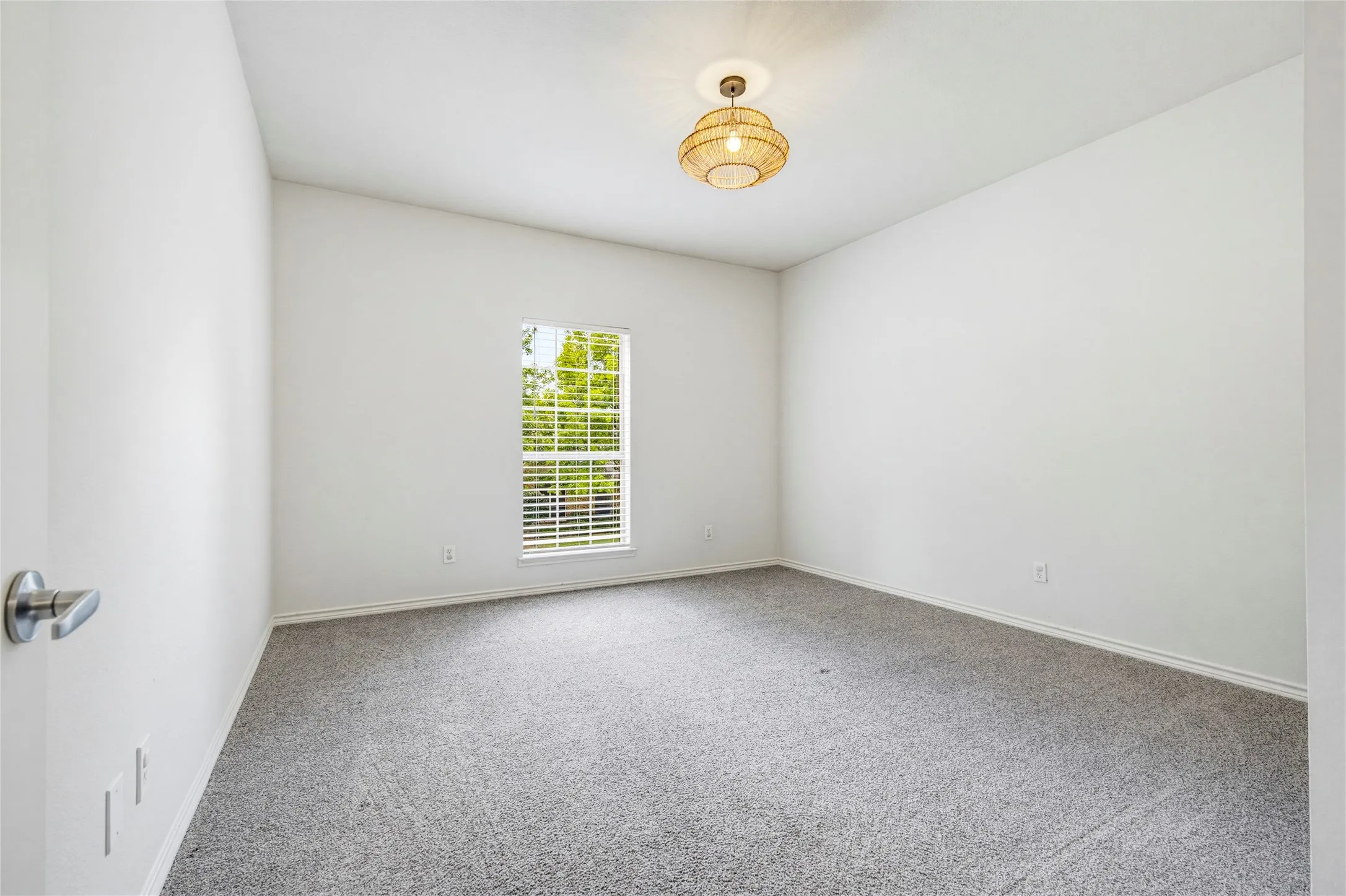 Bright and neutral with recent carpet, ready to serve as a bedroom, guest room, hobby space, or home gym.