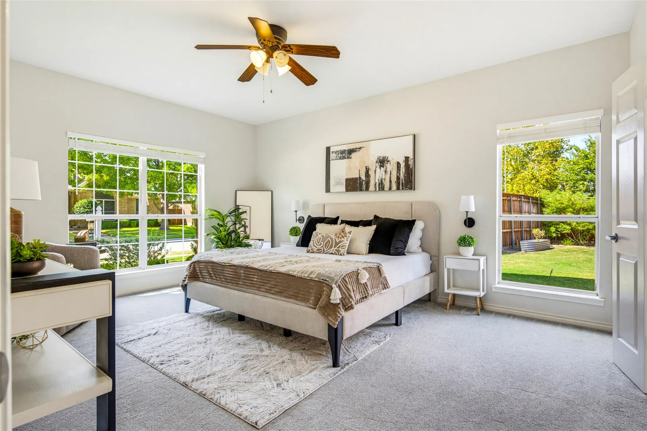 The main-level primary suite offers space, privacy, and natural light pouring in from windows on two sides