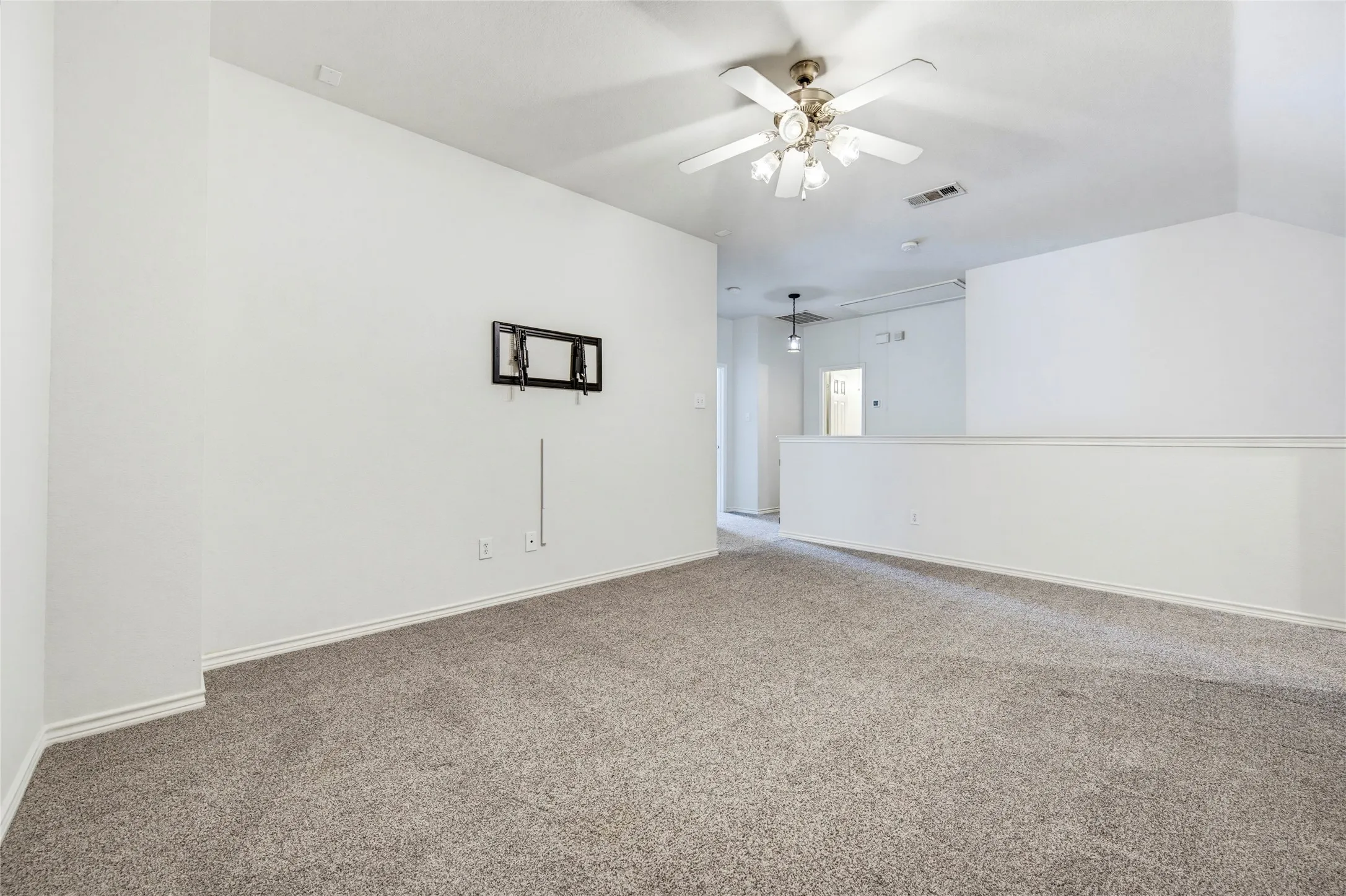A spacious upstairs game room with a ceiling fan and TV wiring, ready for movie nights and playoff Saturdays.
