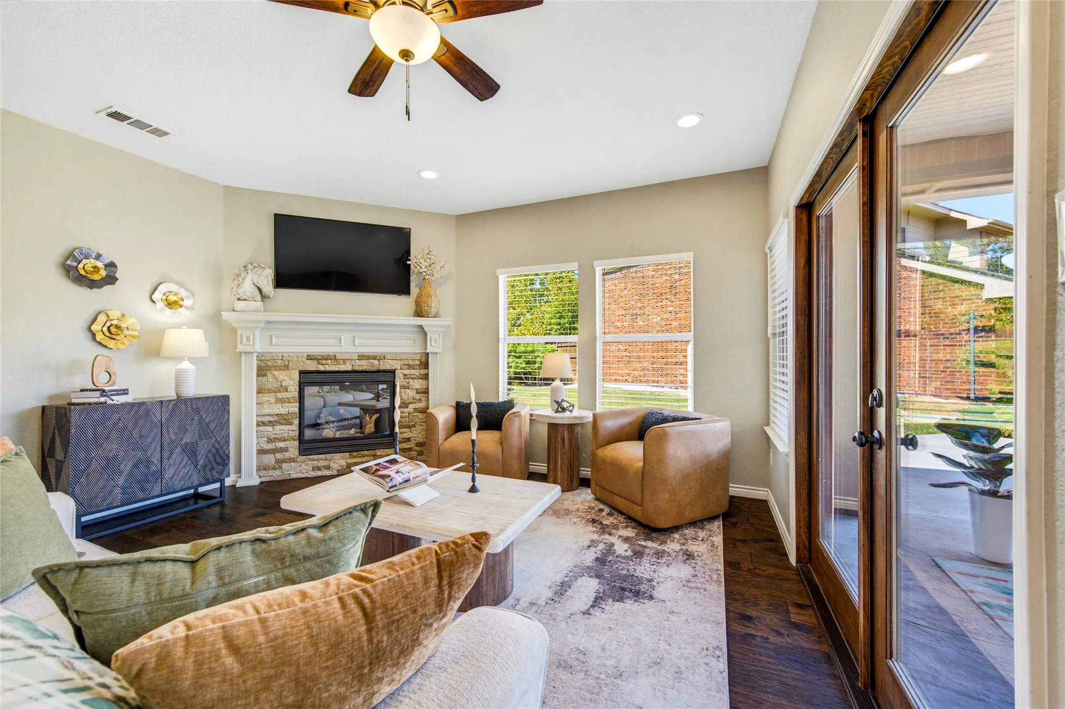 A switch-on gas fireplace anchors the room while a wall of windows keeps it bright. And yes, the framed TV conveys.
