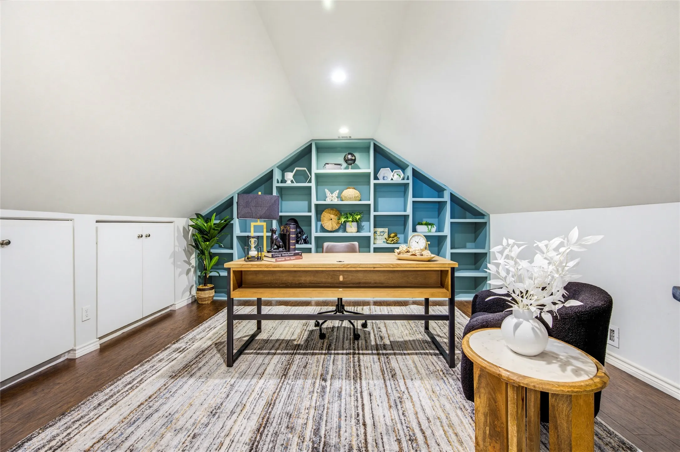 Behind double doors, built-in bookshelves in a bold teal set the tone for a productive workday at home.