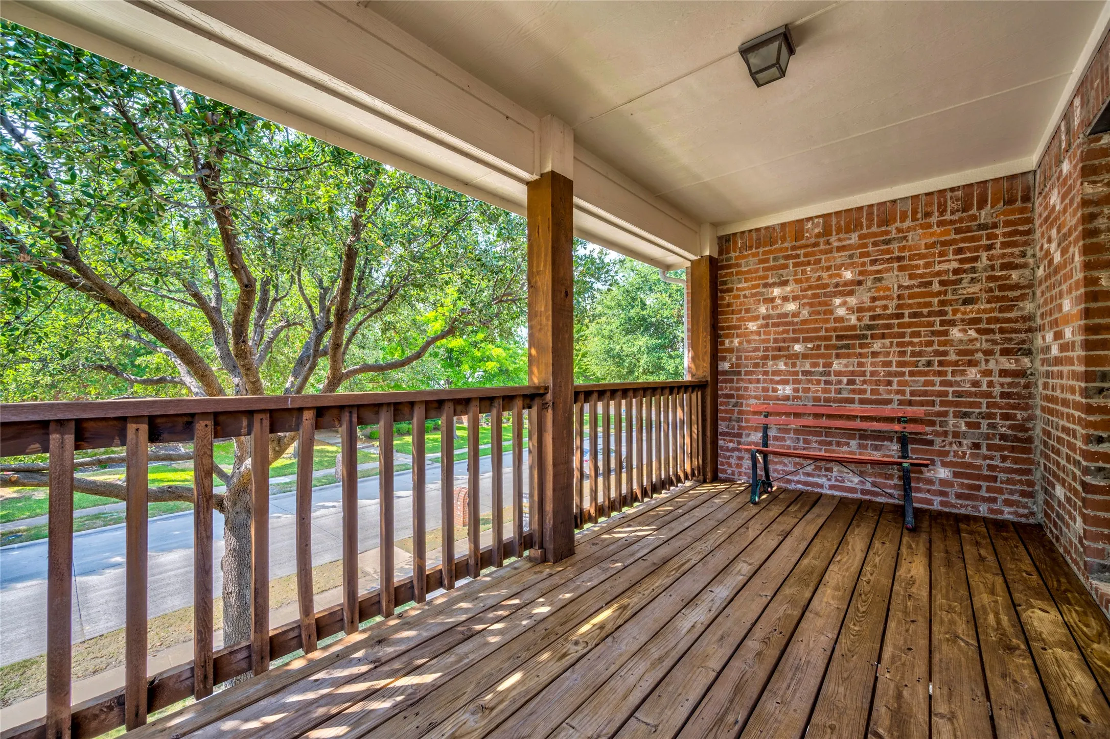 A covered balcony with wood decking and treetop views, giving you a front-row seat for west-facing sunsets or morning coffee.
