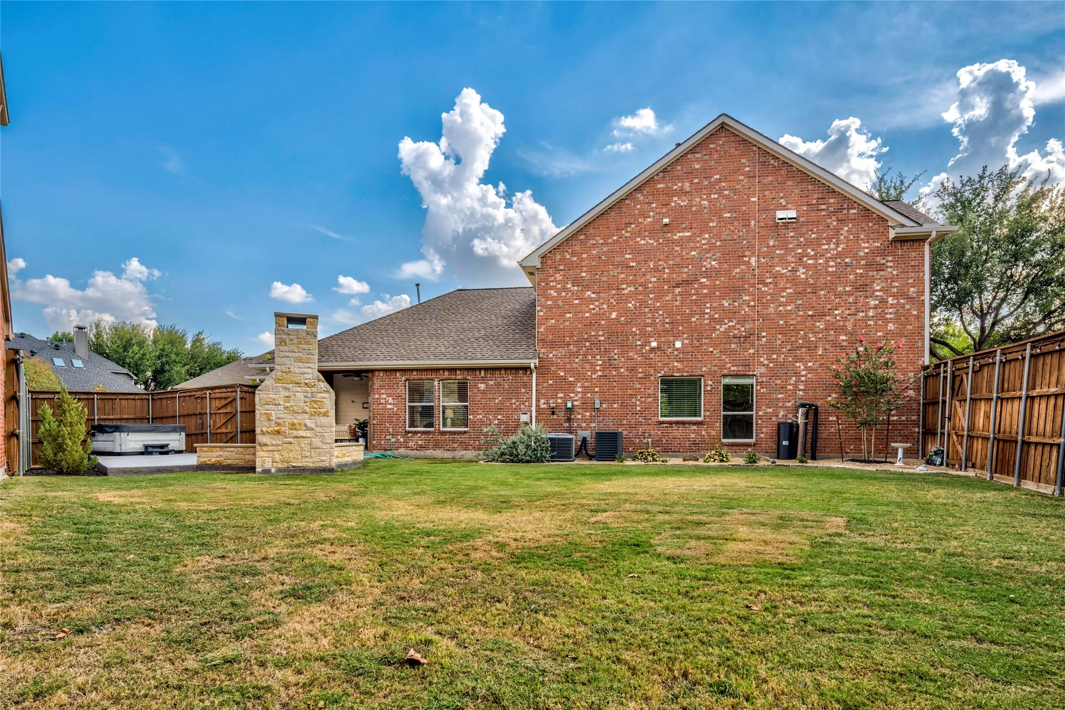 A private, oversized lot with a wide grassy yard and mature trees, offering room to run, toss the ball, and gather all season long.

