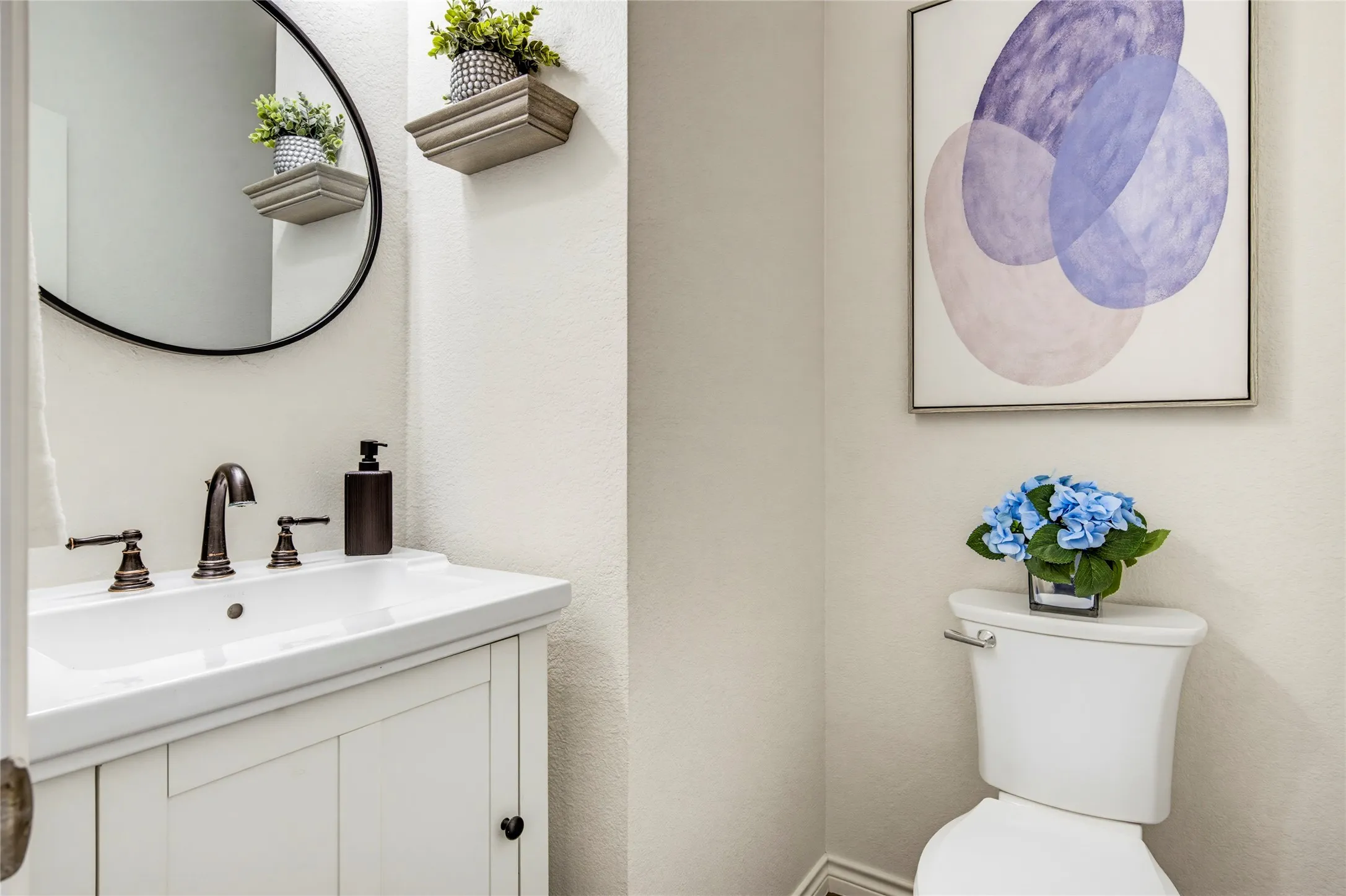 A stylish powder room with a round black mirror and modern fixtures, conveniently located on the main level for guests.