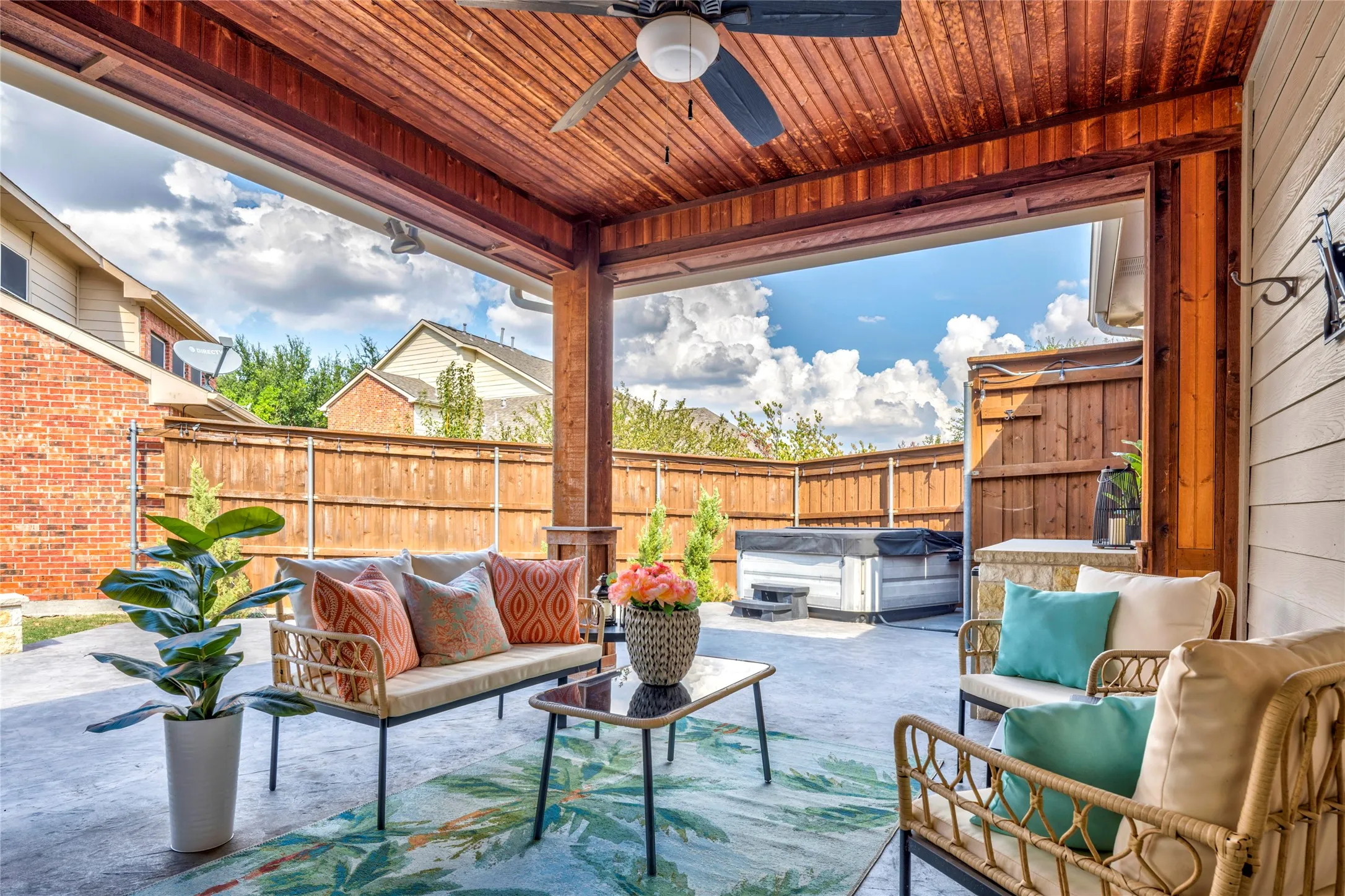 A wood-plank ceiling and ceiling fan keep the covered patio comfortable, with plenty of room to stretch out in the shade.
