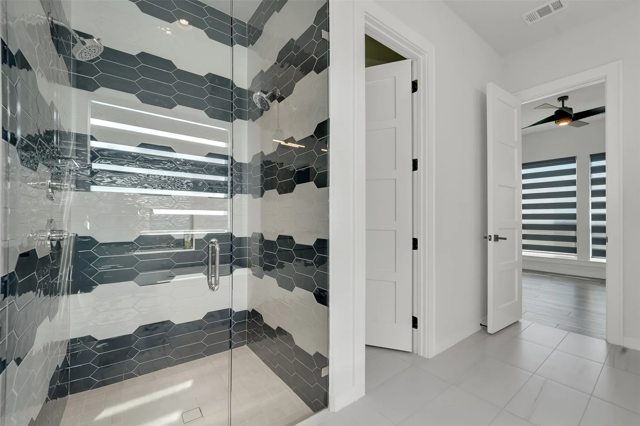 Walk-in shower with dual shower heads and hexagonal tilework