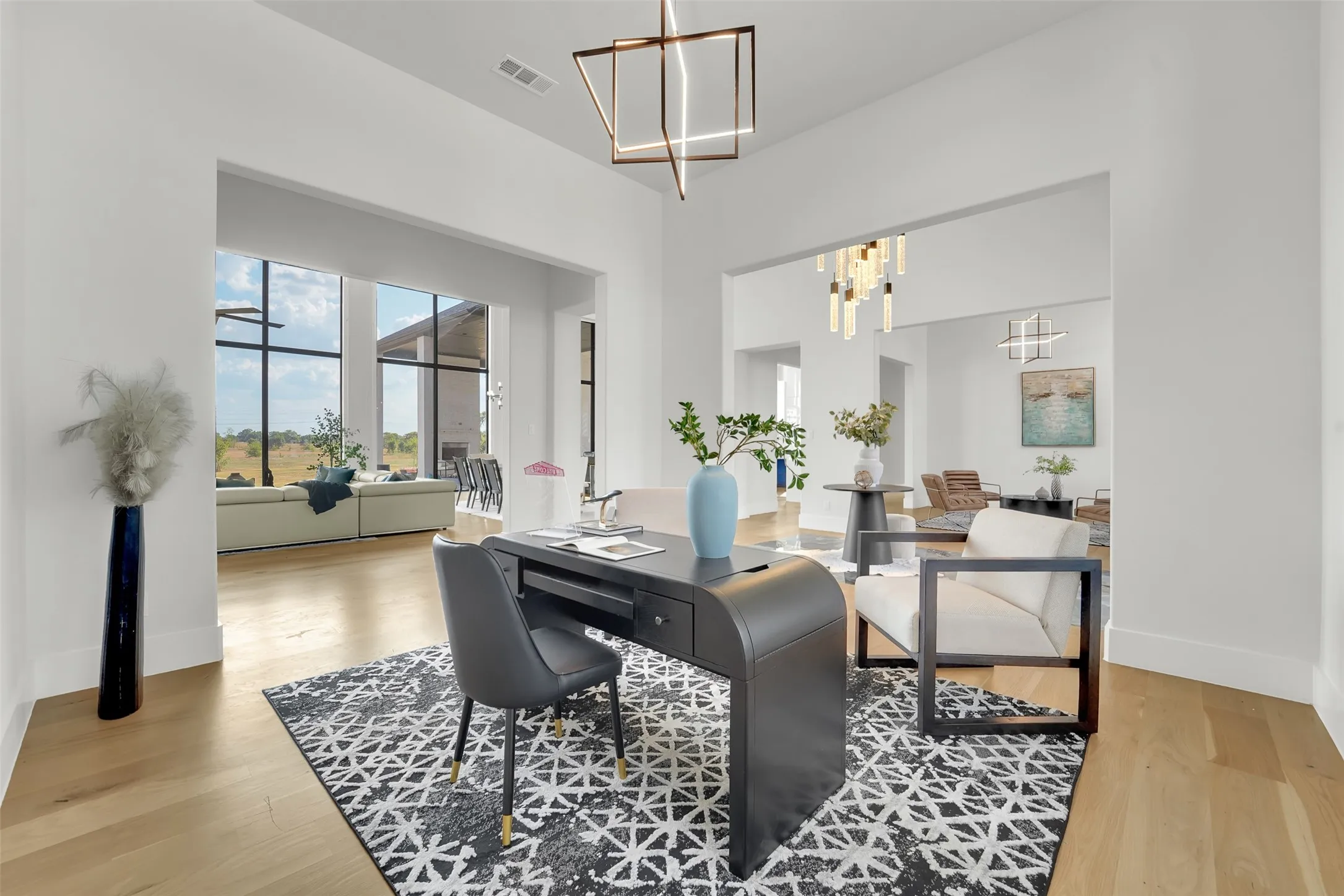 High ceilings with recessed lighting, light wood-finish flooring, expansive windows, and modern architectural light fixtures