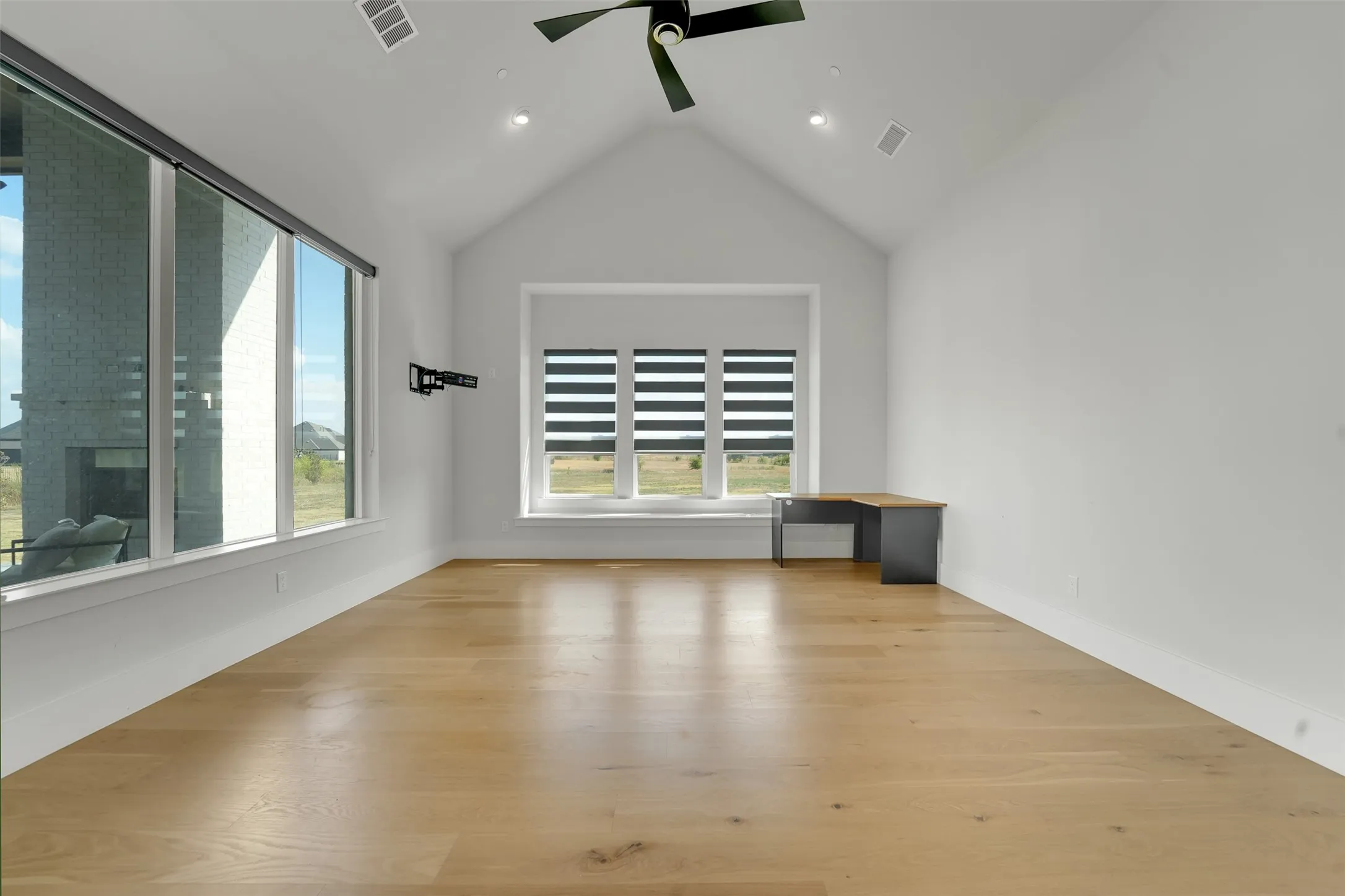 Vaulted ceiling with recessed lighting and a ceiling fan