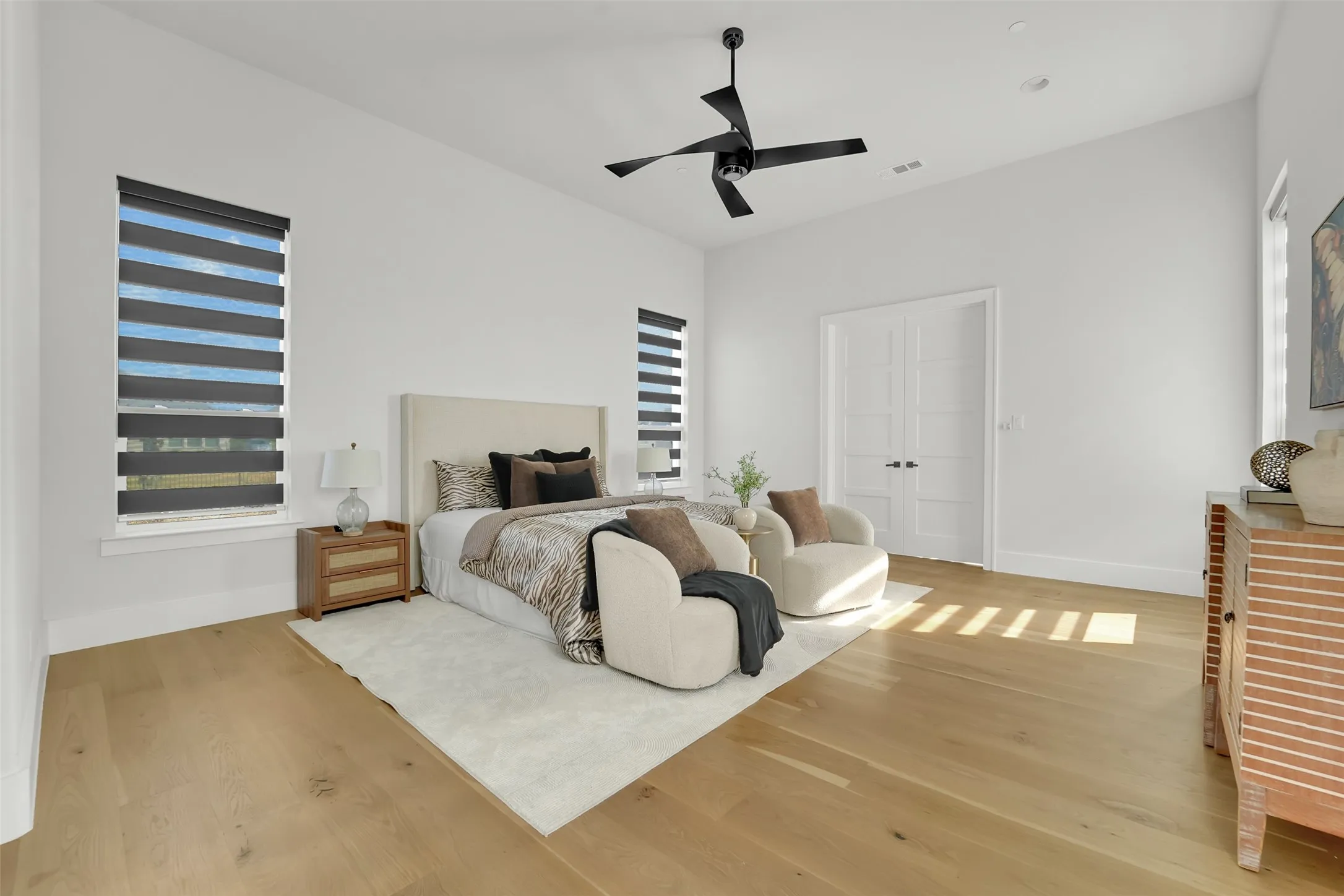 Wood-finish flooring, vaulted ceiling, dual panel interior doors, and a contemporary ceiling fan