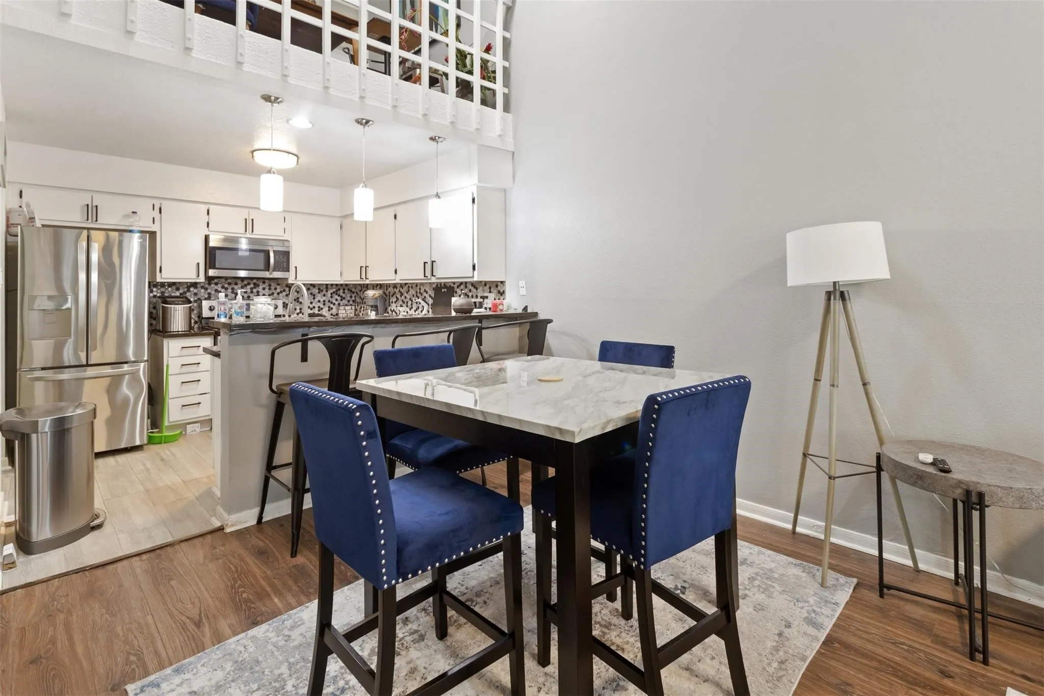 Kitchen with stainless steel appliances, white cabinetry, dark countertops, and a patterned tile backsplash