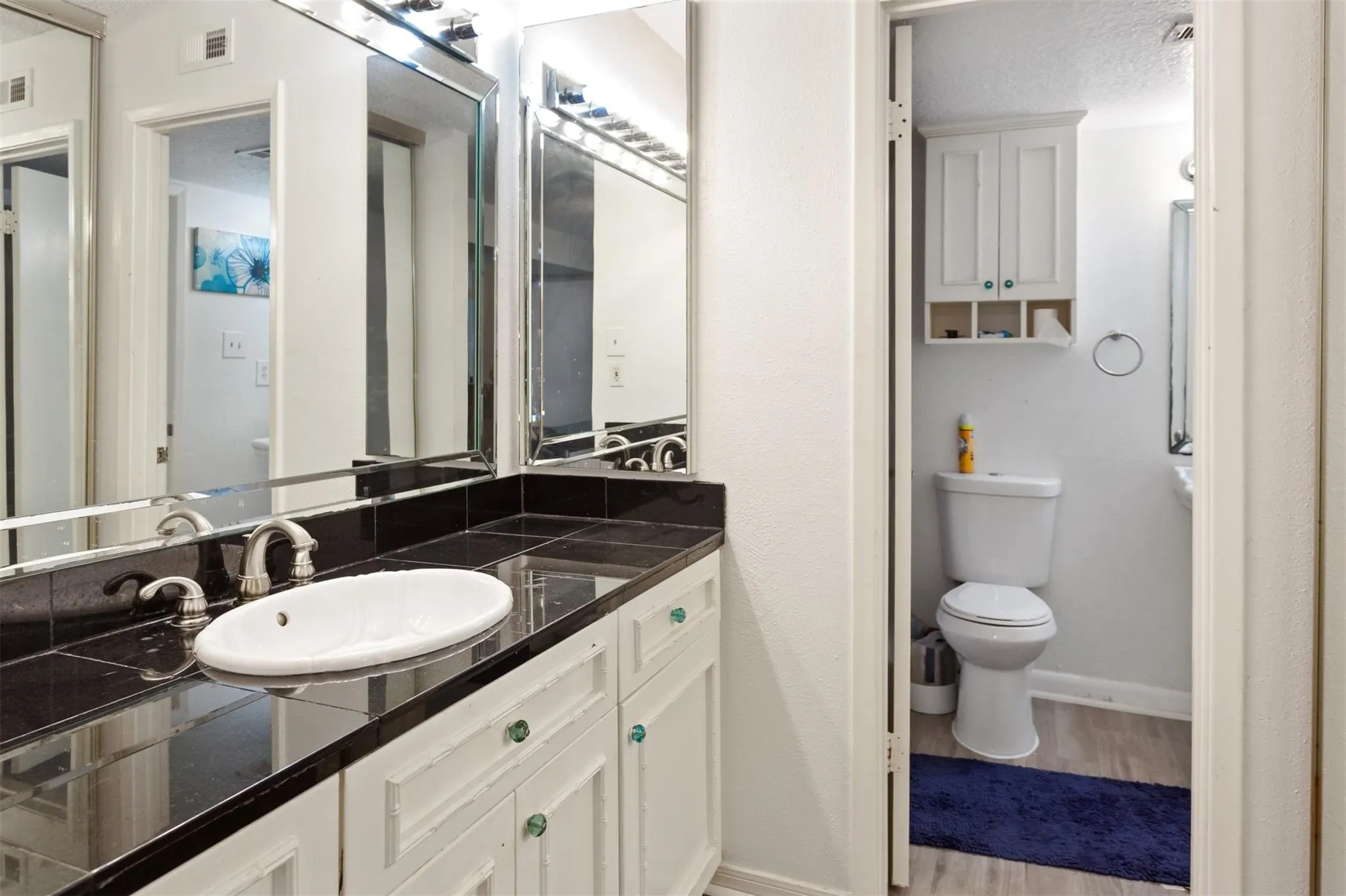 Bathroom 1 - Vanity with a white oval sink, chrome faucet, and dark tiled countertop