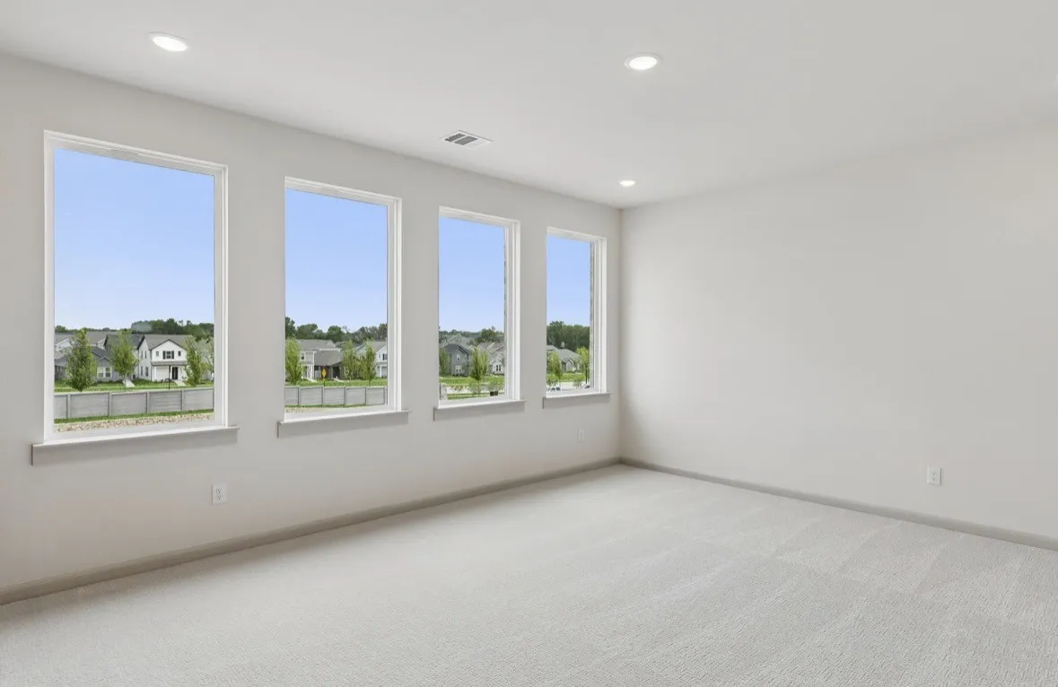 Four large windows, neutral wall paint, recessed lighting, and light-toned carpeting