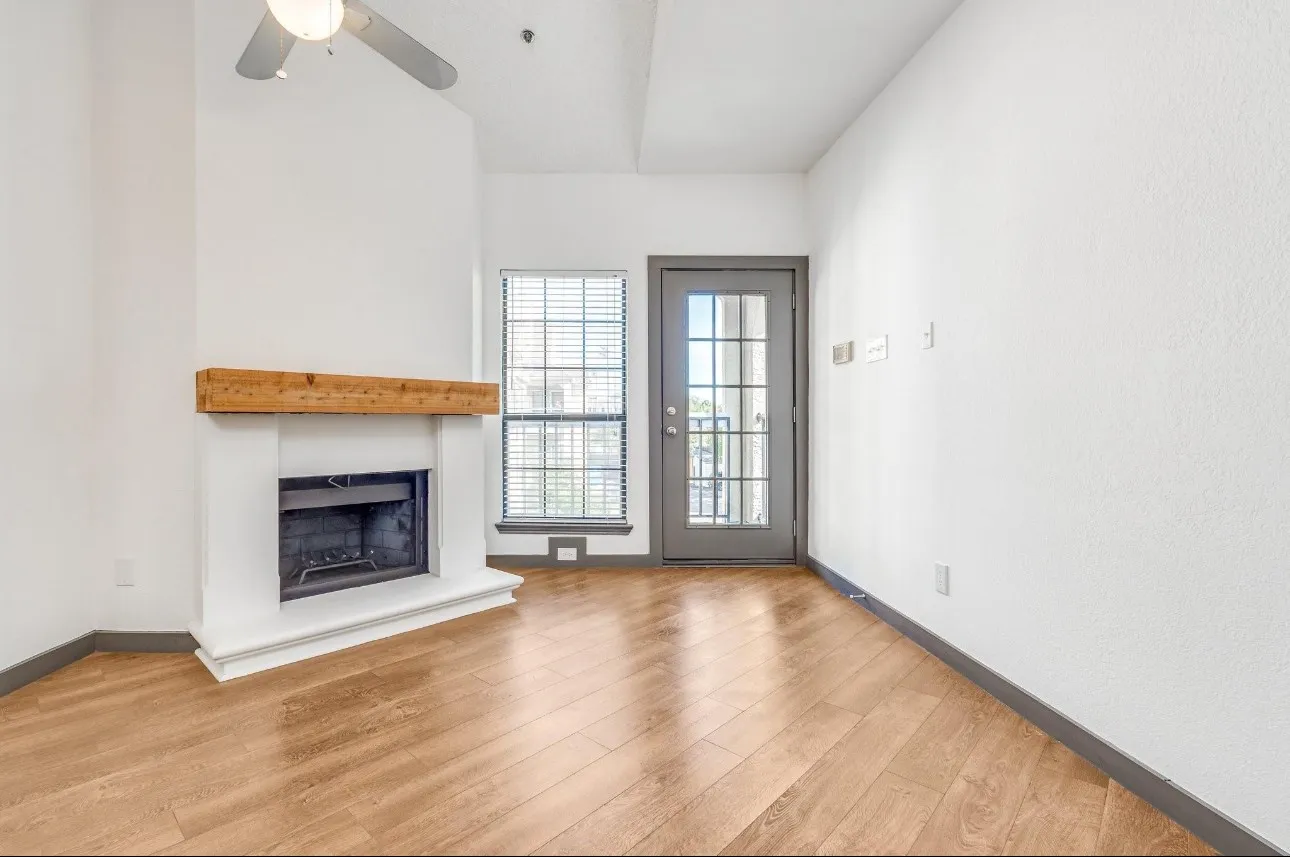 Unfurnished living room featuring ceiling fan and light wood-type flooring