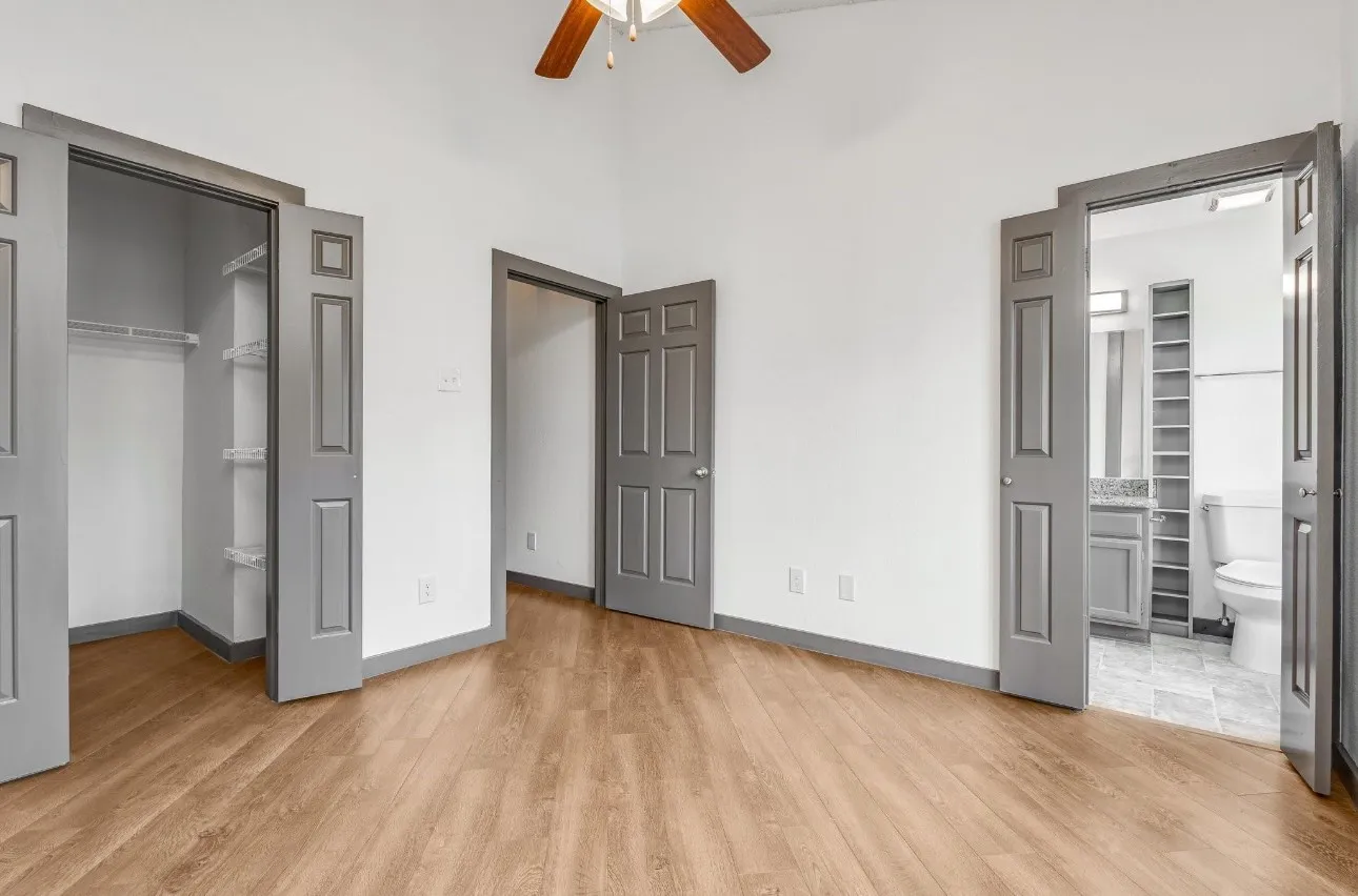 Unfurnished bedroom featuring a walk in closet, connected bathroom, light hardwood / wood-style floors, and a closet