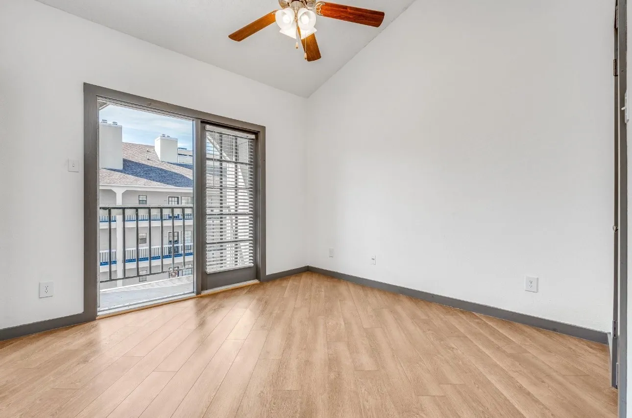 Spare room with ceiling fan, lofted ceiling, and light hardwood / wood-style floors