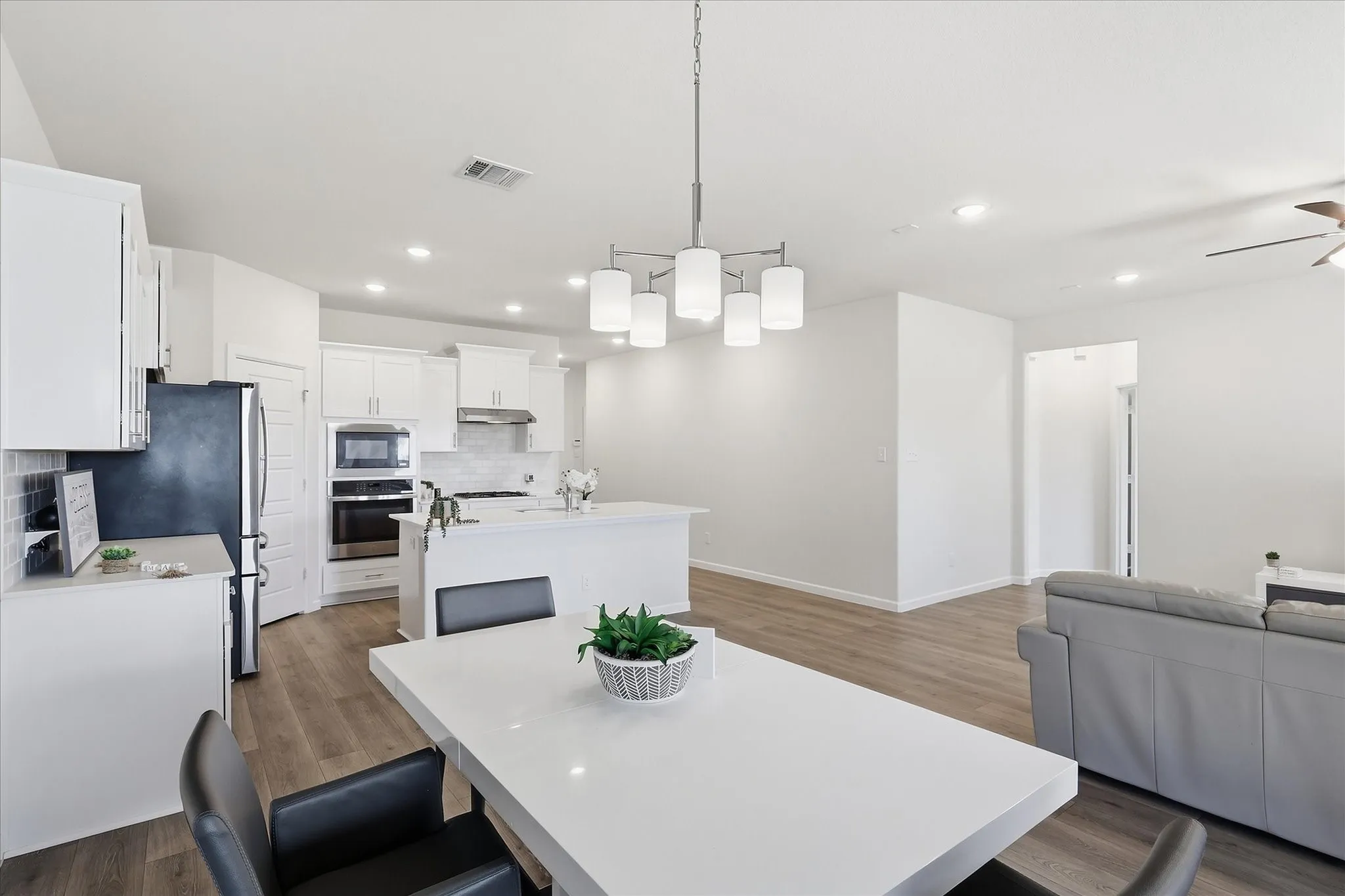 Open-concept kitchen with white cabinetry and stainless steel appliances
