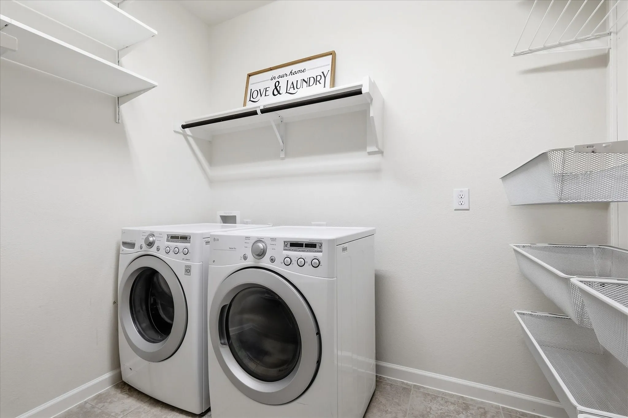White wall-mounted shelving, overhead clothes hanging rod, and integrated storage baskets