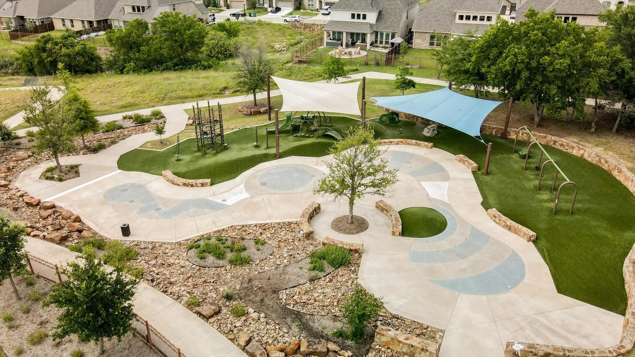 turf play areas, shade structures, built-in play equipment, and stone retaining walls