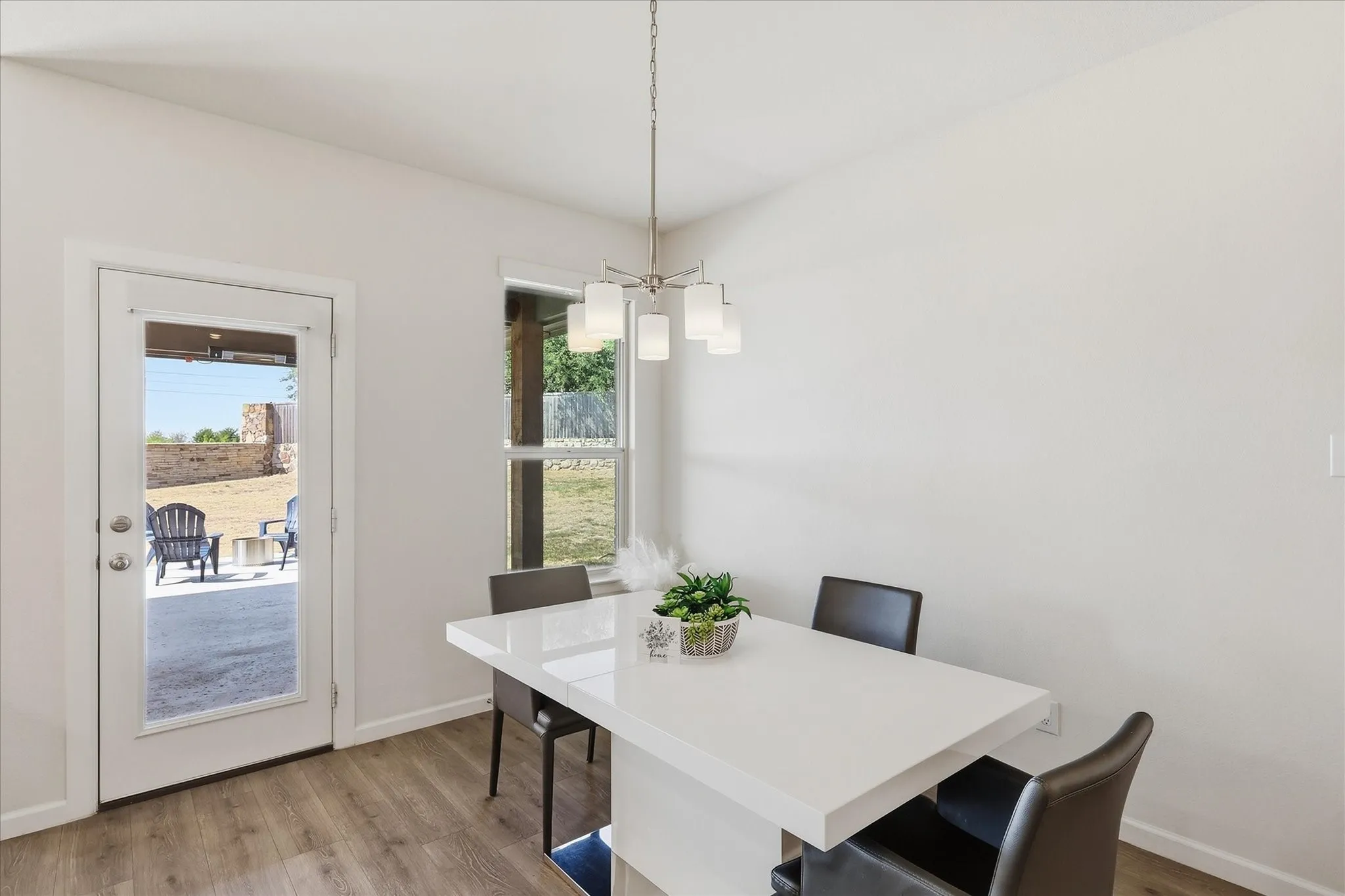 Wood-finish flooring, white walls, and a contemporary chandelier