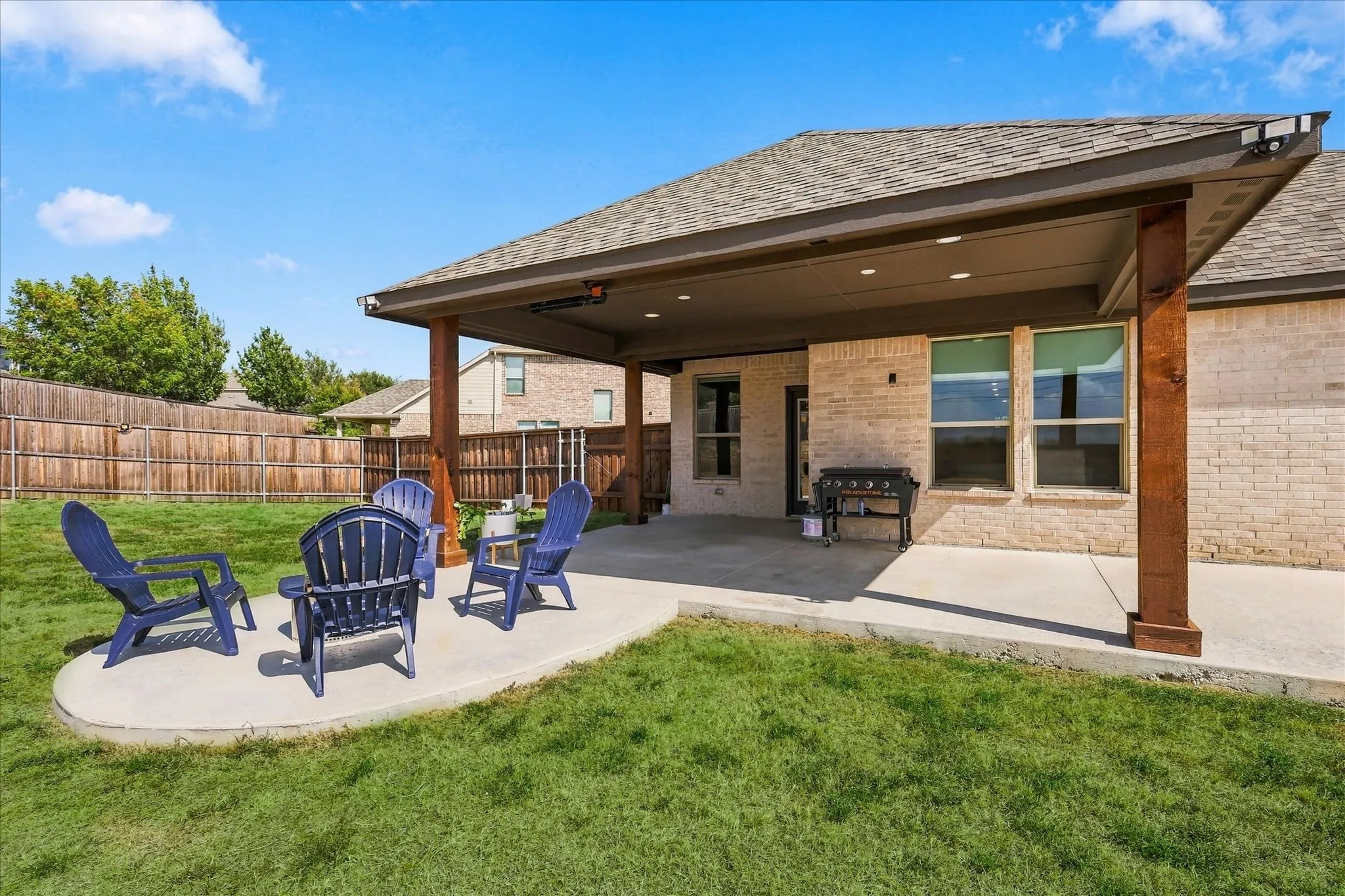 Covered patio featuring recessed lighting and a ceiling fan, concrete patio, brick exterior, and a wood privacy fence