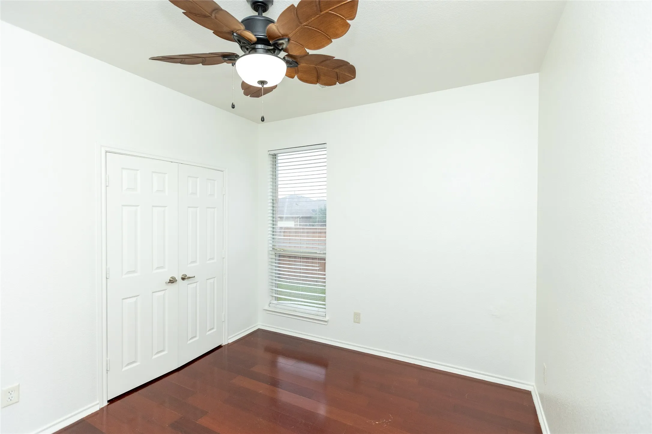 Wood-finish flooring with a ceiling fan and integrated light fixture