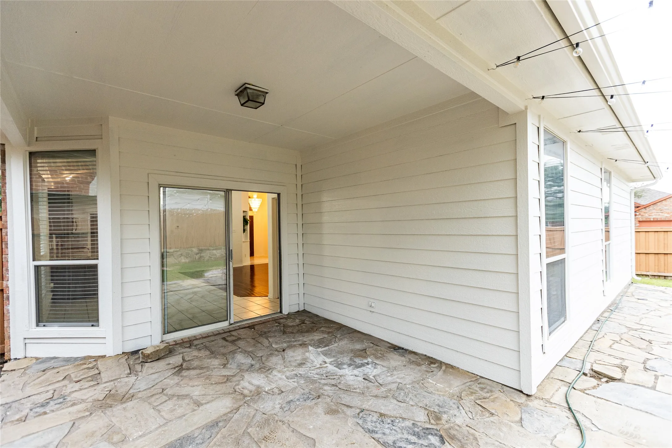 Covered patio with flagstone paving and a single built-in overhead light fixture
