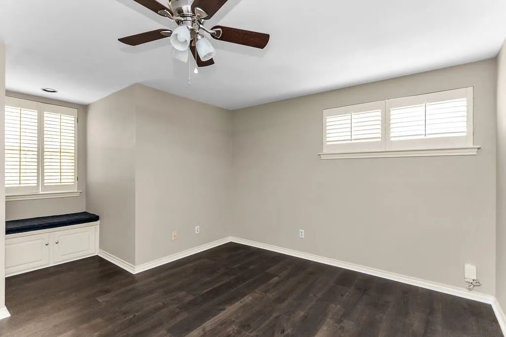 Dark wood-finish flooring, recessed lighting, and a ceiling fan with integrated lighting